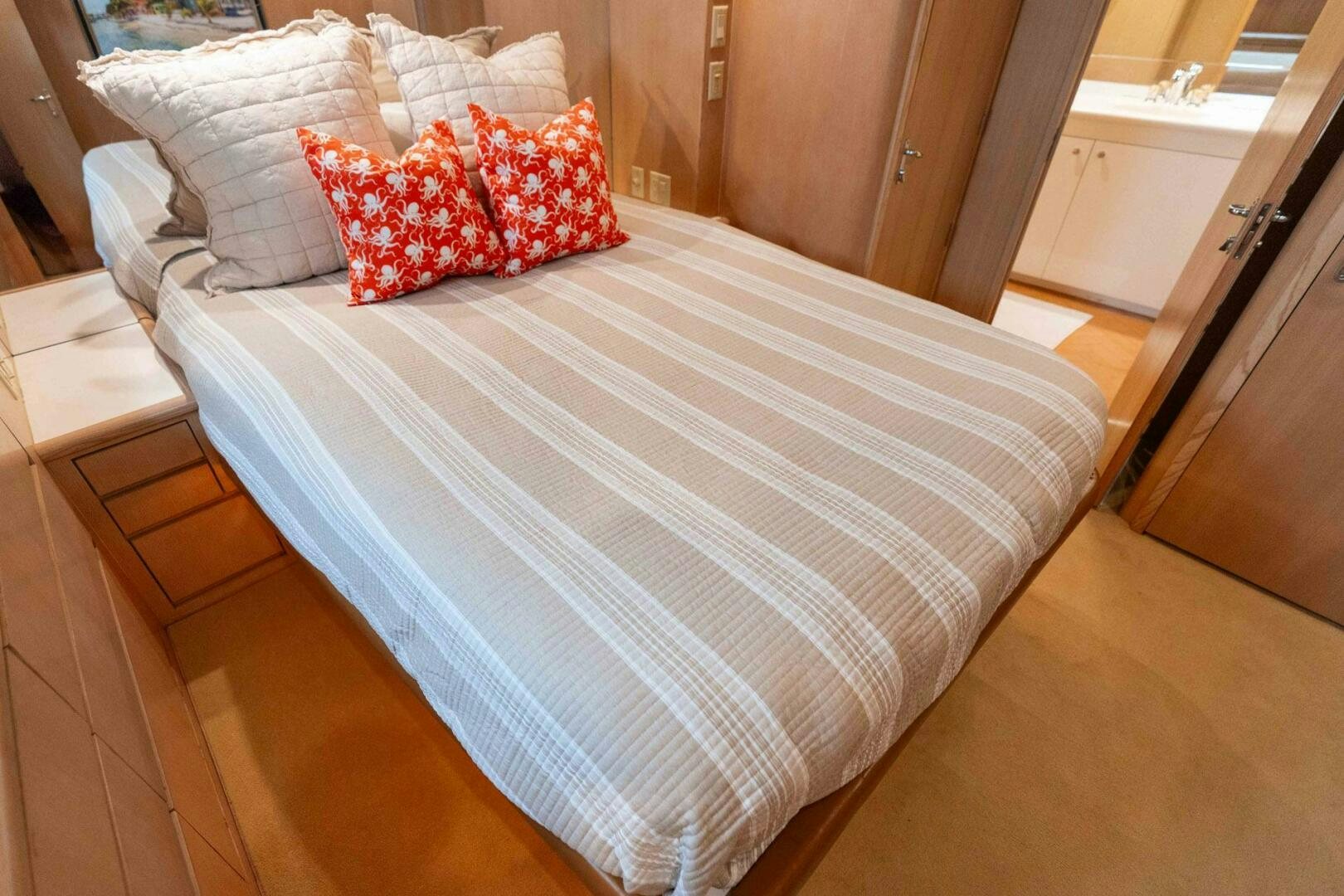 a bed with white and red pillows aboard KRAKEN Yacht for Sale
