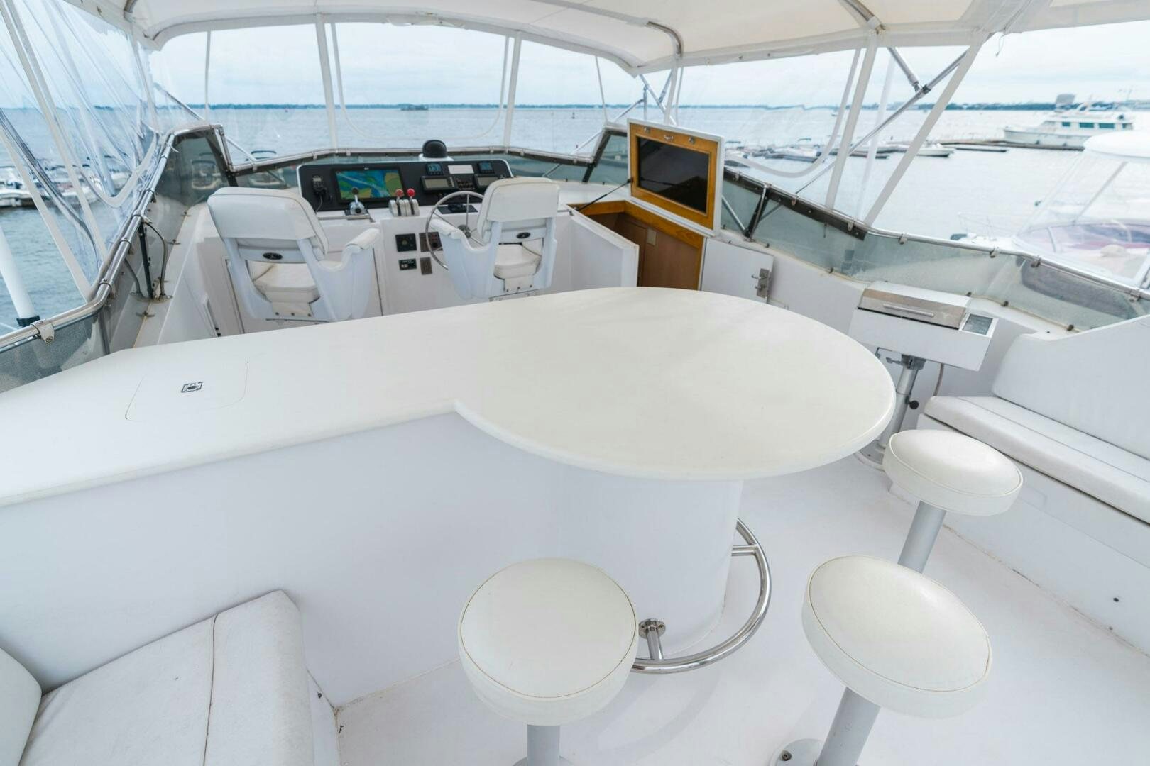 a large white room with a large window and a table with chairs aboard KRAKEN Yacht for Sale