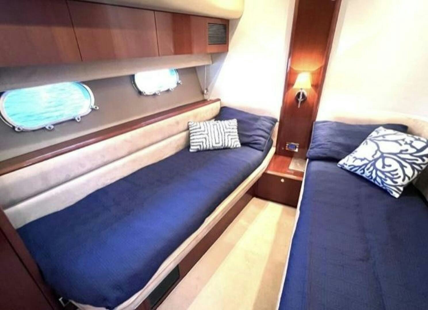 a bed with a blue blanket aboard UNIQ Yacht for Sale