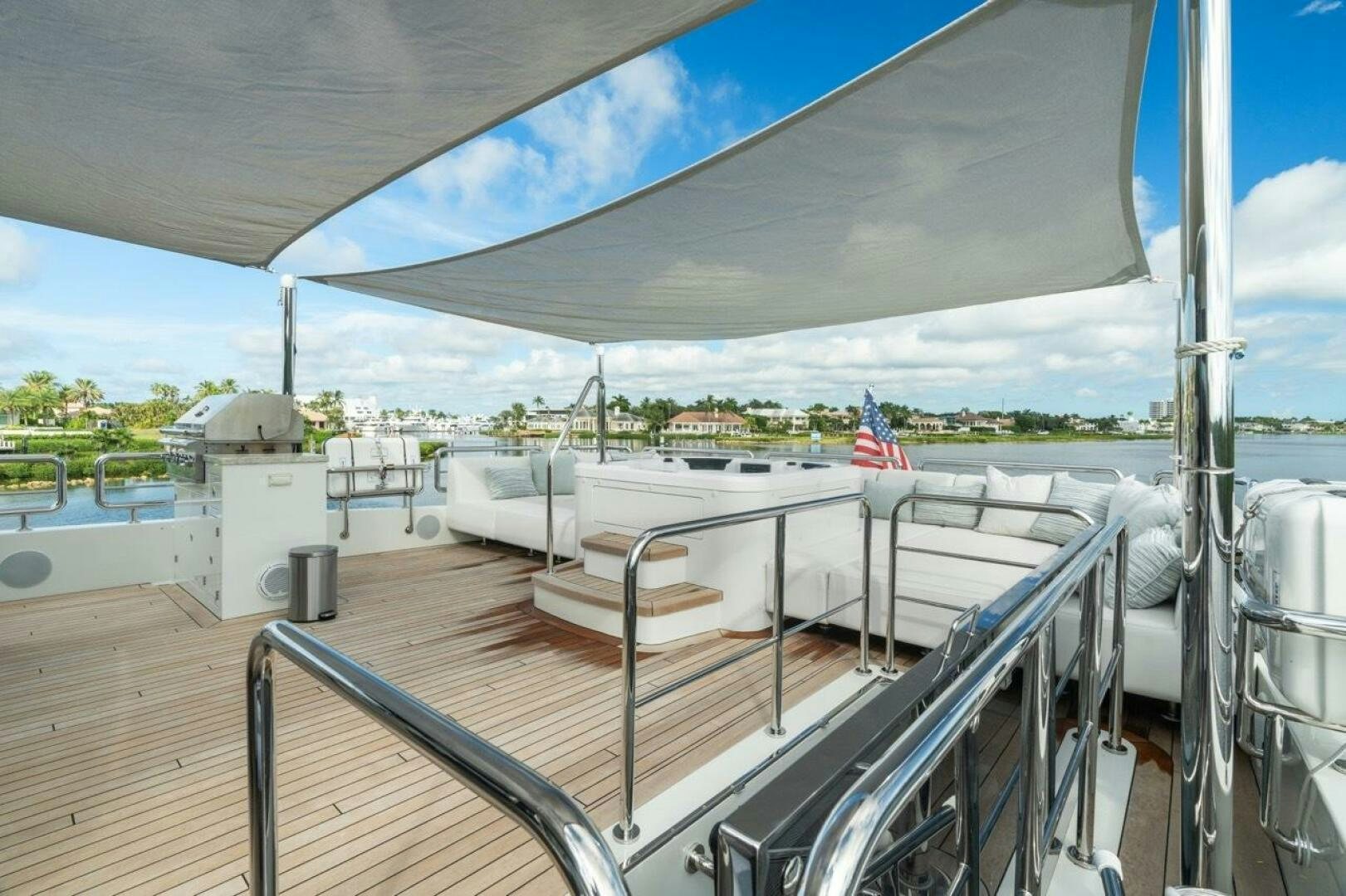a deck with a large white boat and a flag on it aboard LADY G Yacht for Sale