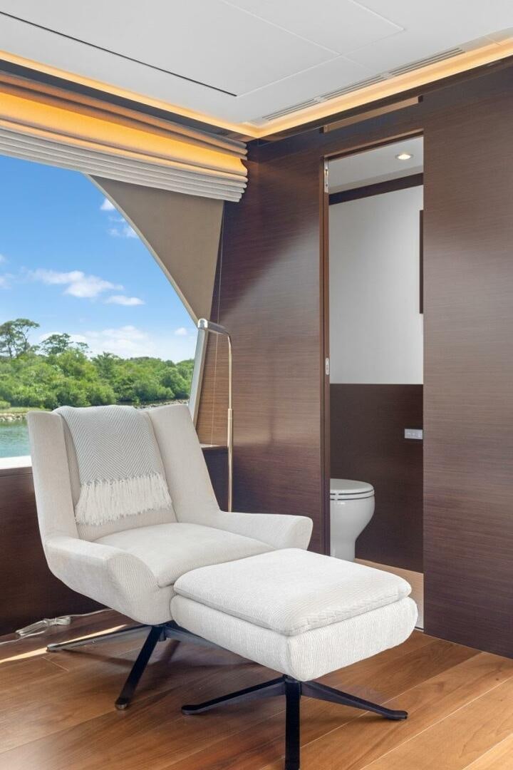 a room with a chair and a window aboard LADY G Yacht for Sale