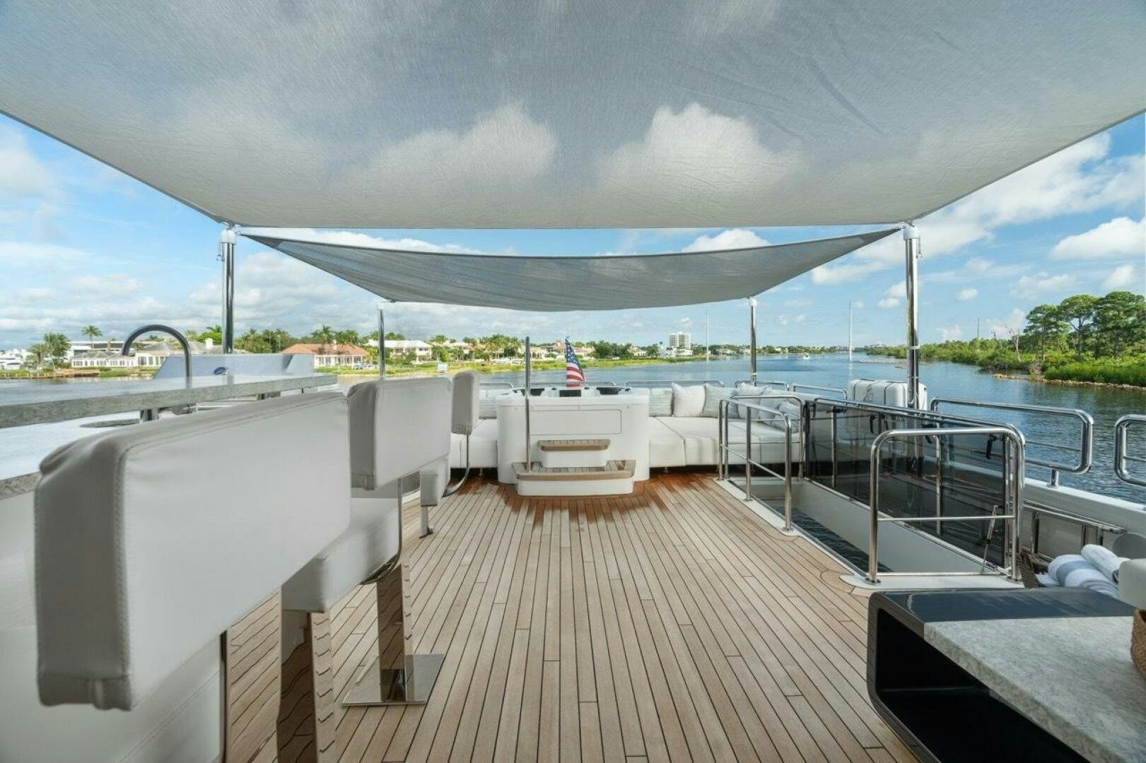 a deck with chairs and a large blue and white awning over water aboard LADY G Yacht for Sale