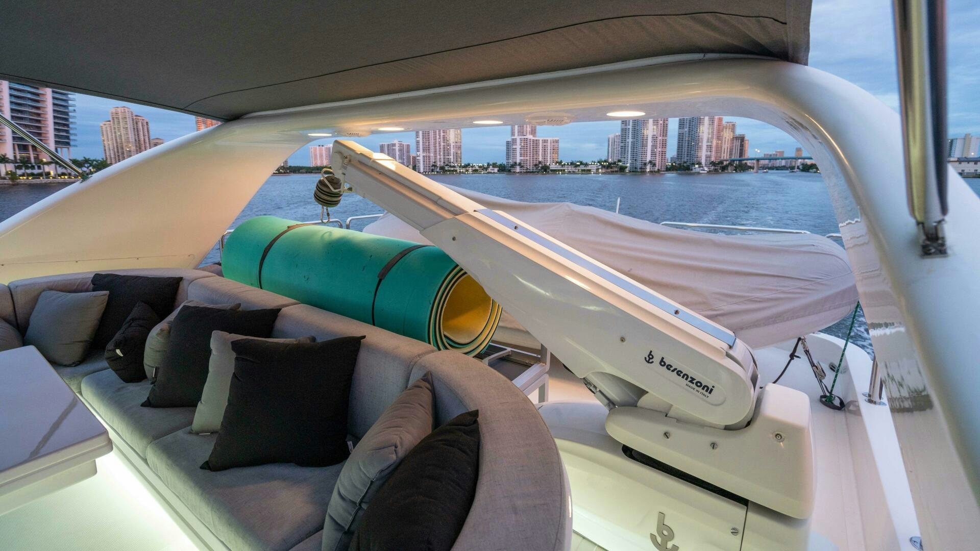 a person's feet on a couch with a large city in the background aboard LOSAND Yacht for Sale