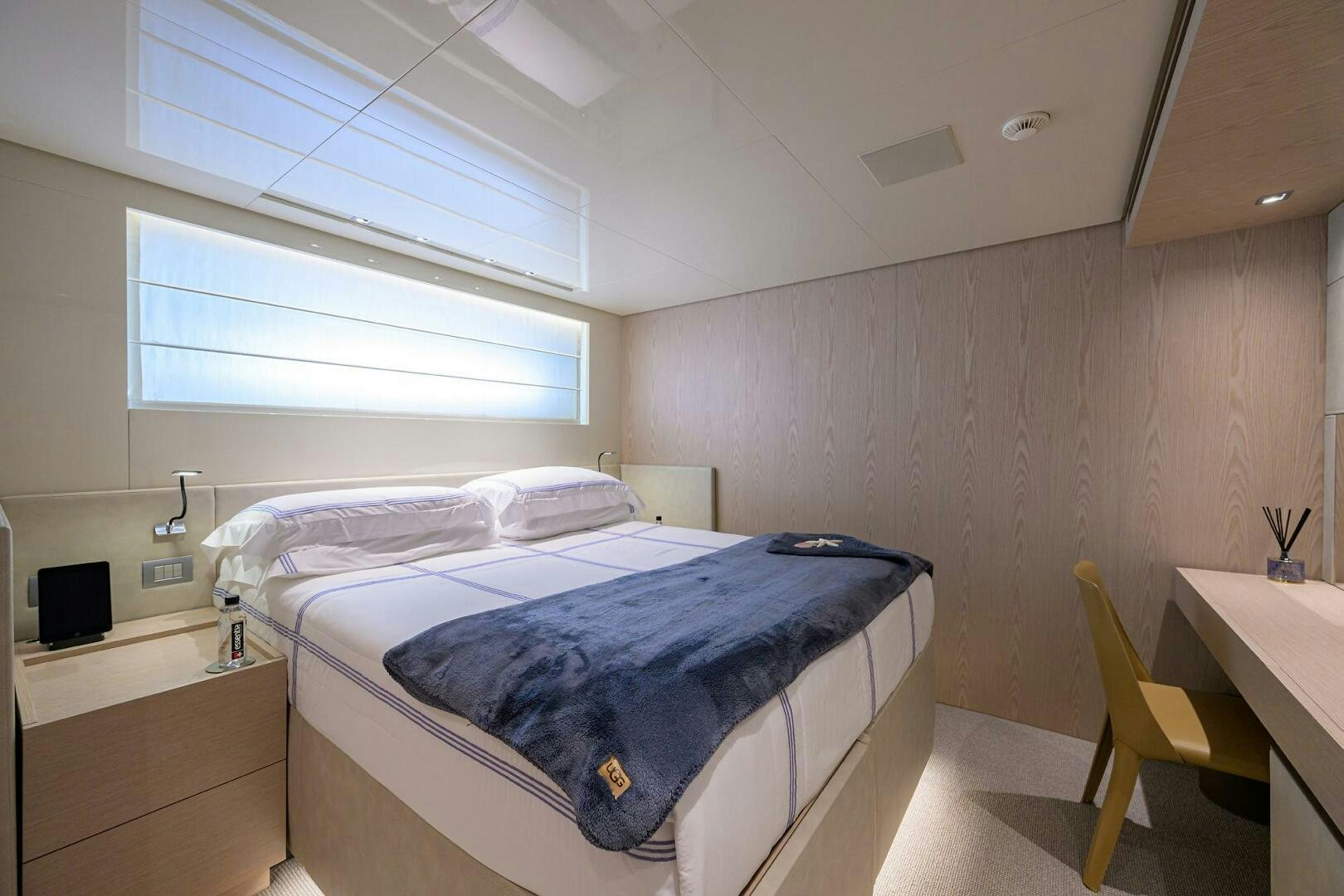 a bedroom with a bed and a desk aboard GLORY Yacht for Sale