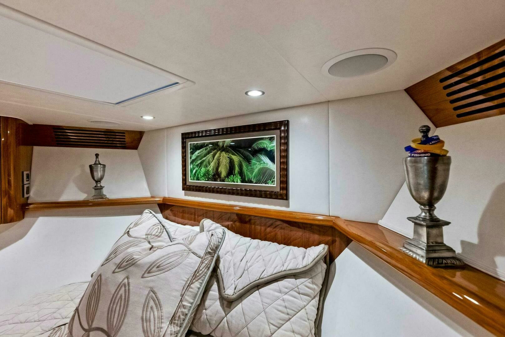 a bed with a painting on the wall aboard PRINCESS LILY Yacht for Sale