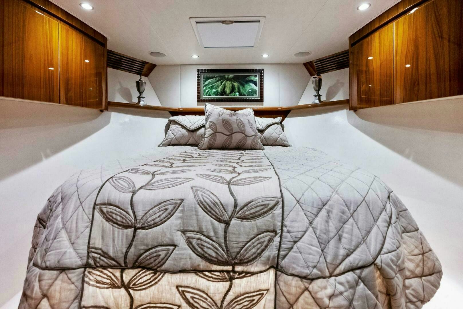 a bed with a television on the wall aboard PRINCESS LILY Yacht for Sale