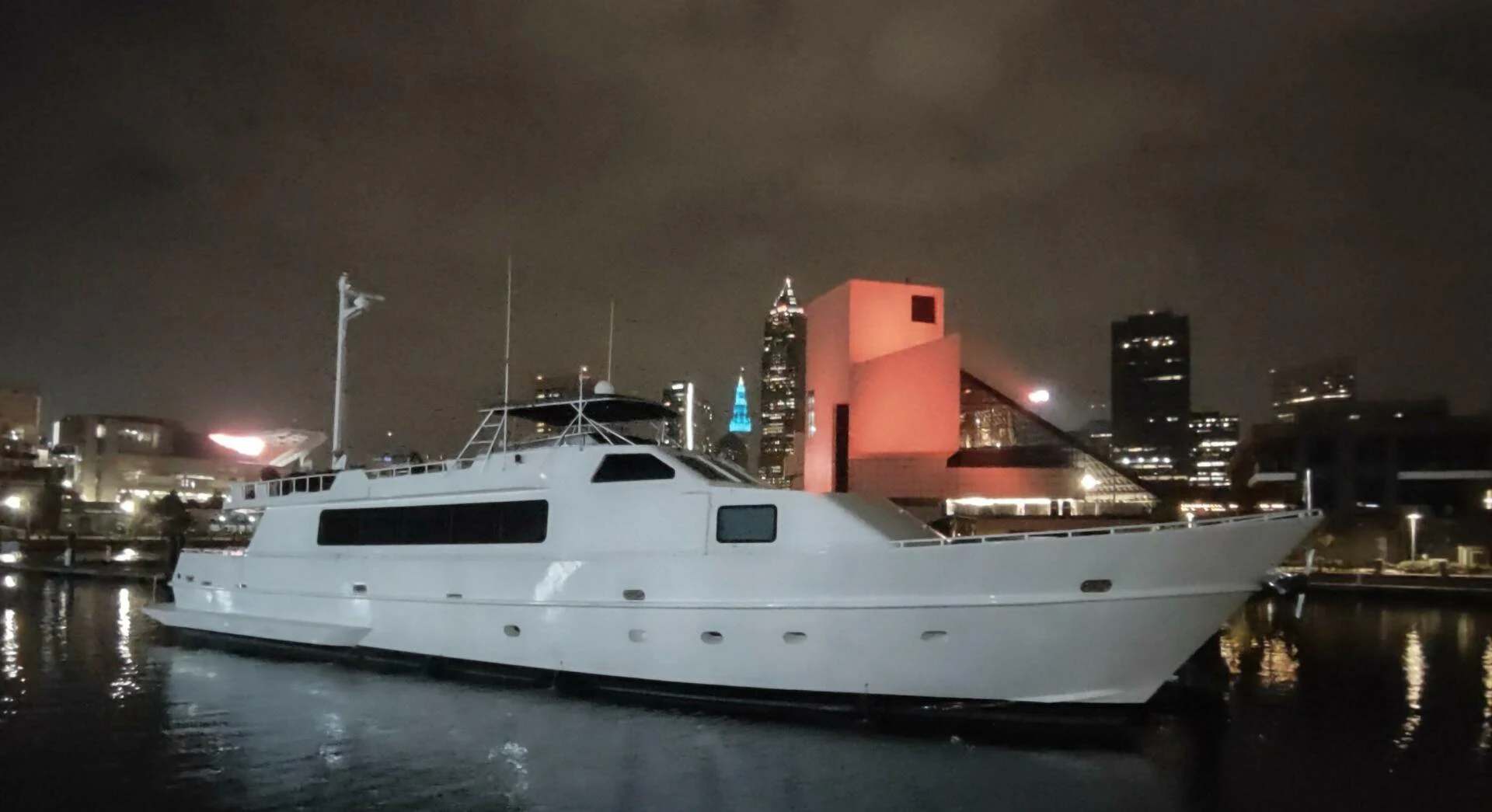 a large white boat in a harbor aboard PIER PRESSURE Yacht for Sale