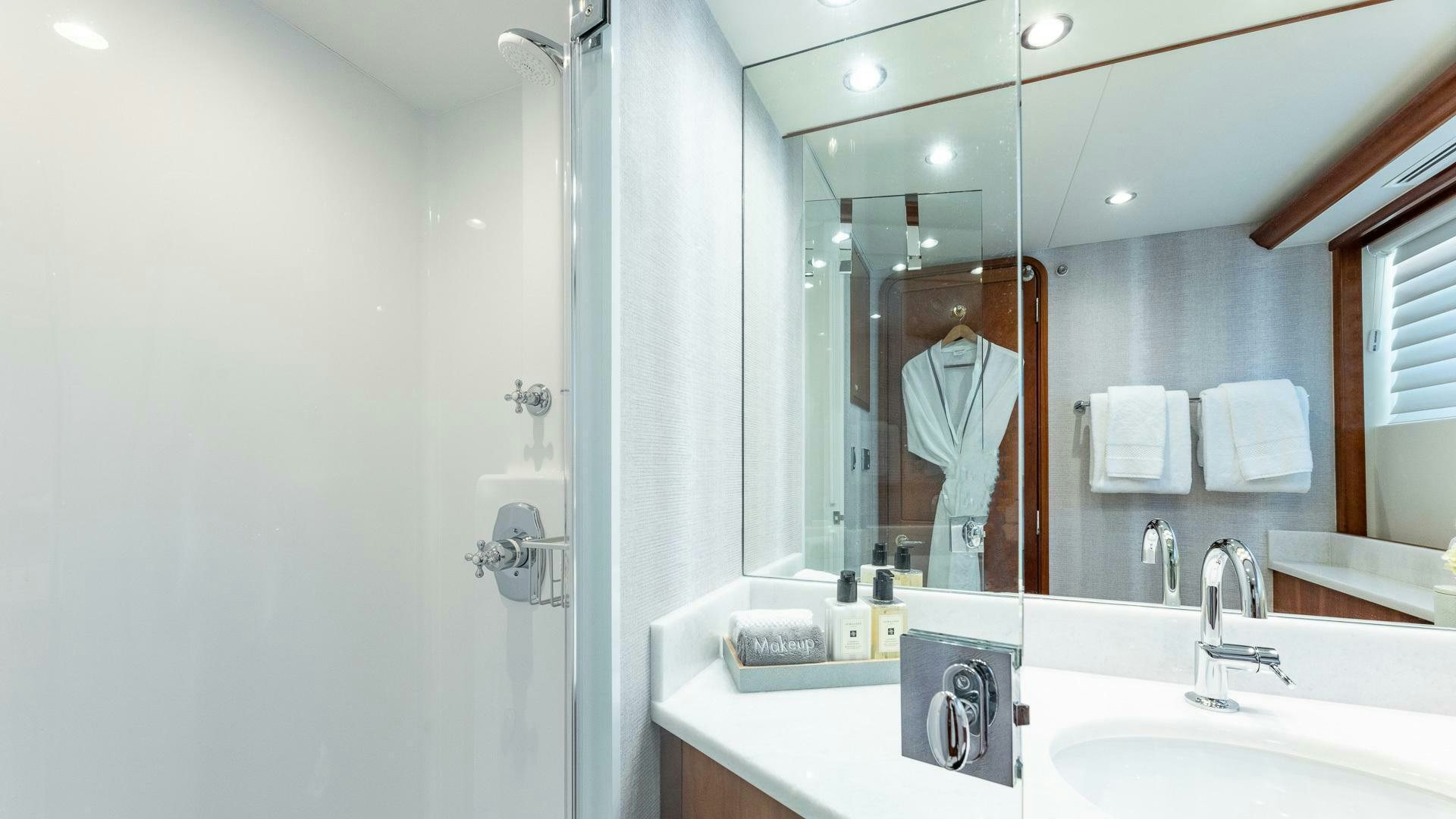 a person taking a picture of themselves in a bathroom mirror aboard NO SHORTCUTS Yacht for Sale