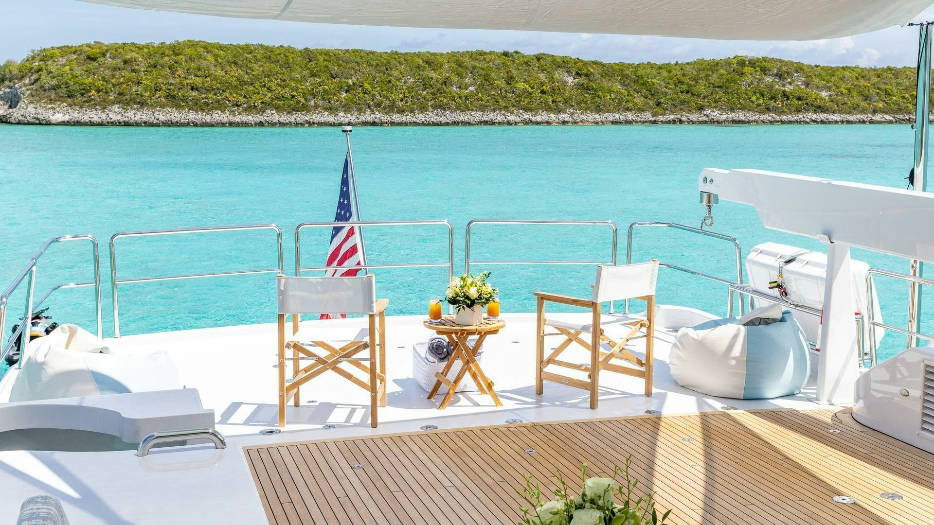 a deck with chairs and tables on it by the water aboard NO SHORTCUTS Yacht for Sale