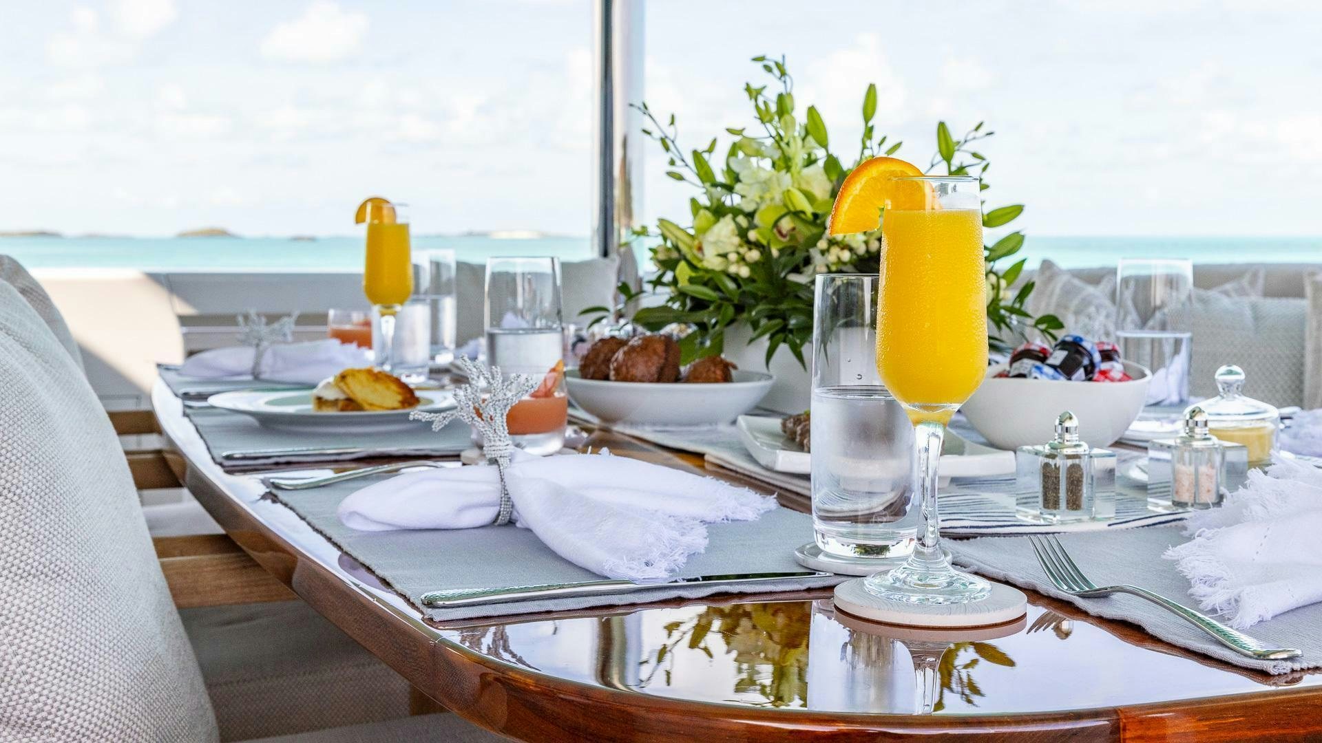 a table with plates and glasses on it aboard NO SHORTCUTS Yacht for Sale