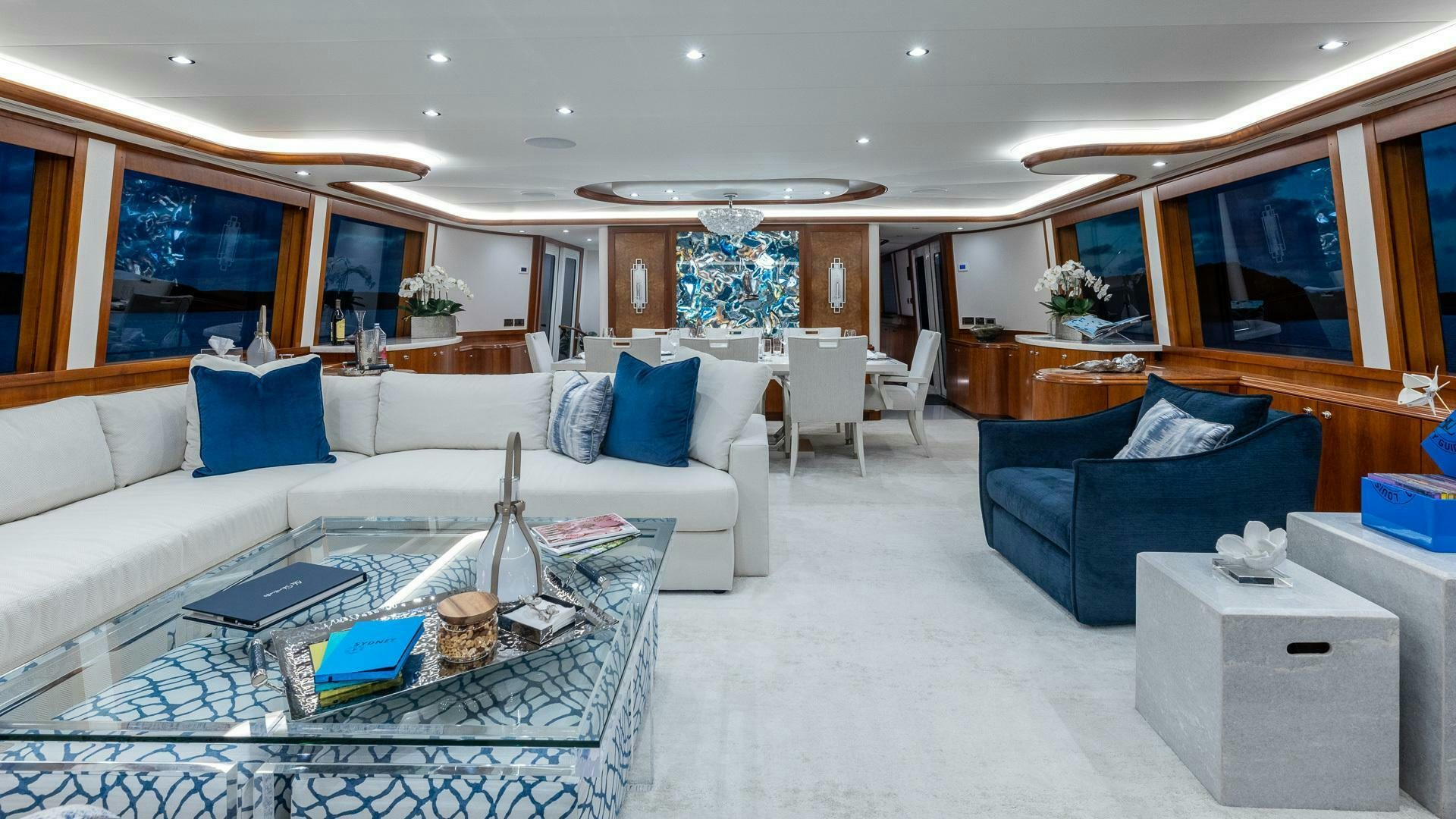 a living room with a large white couch and a large window aboard NO SHORTCUTS Yacht for Sale