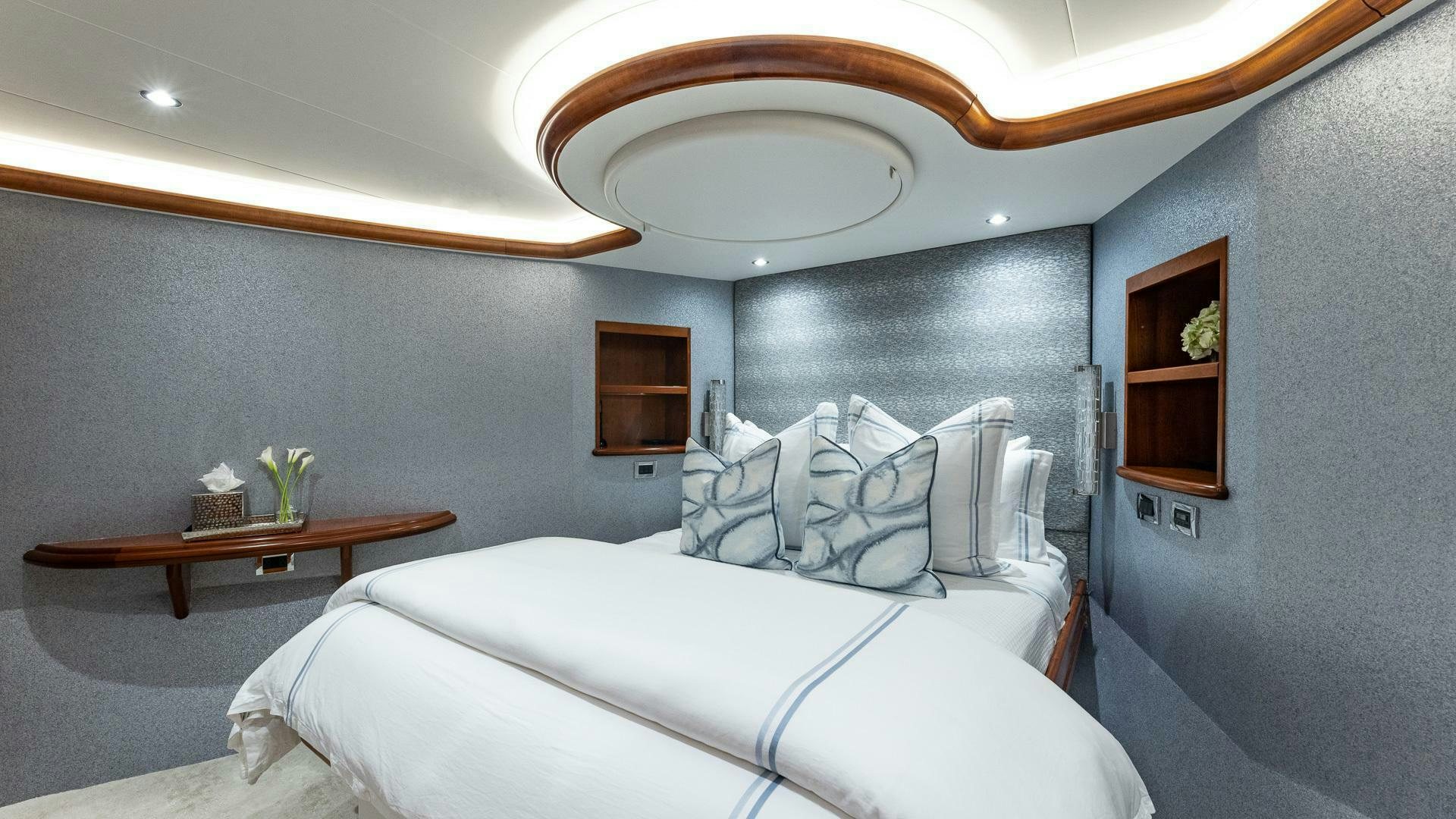 a bedroom with a bed and a table aboard NO SHORTCUTS Yacht for Sale