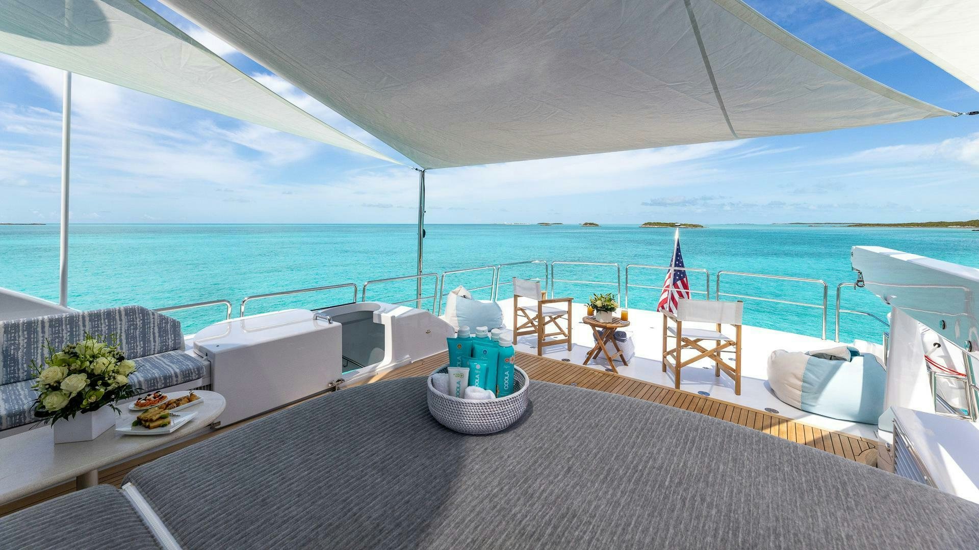 a large white lounge chair on a deck overlooking a large body of water aboard NO SHORTCUTS Yacht for Sale