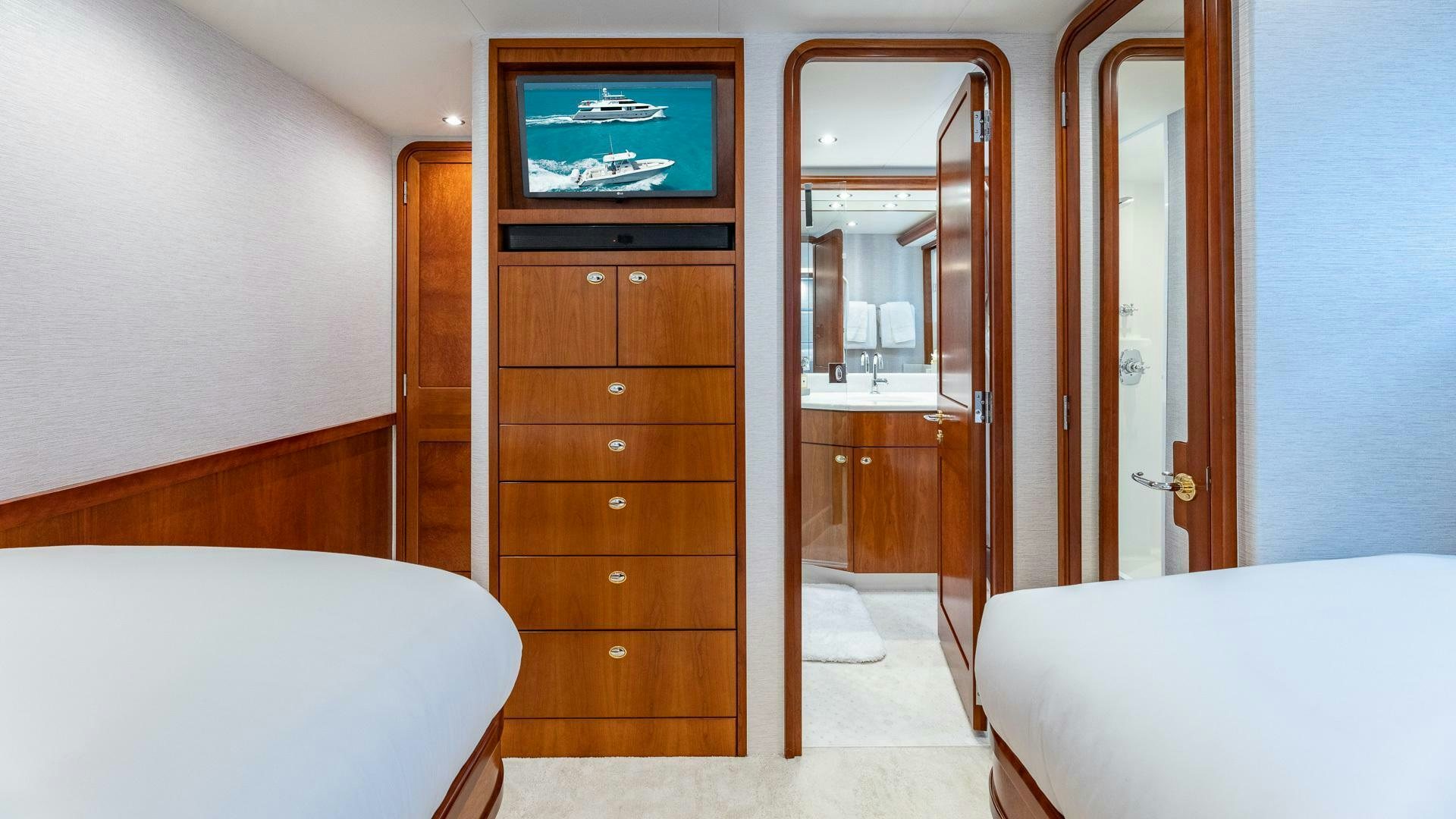 a room with a bed and a television on the wall aboard NO SHORTCUTS Yacht for Sale