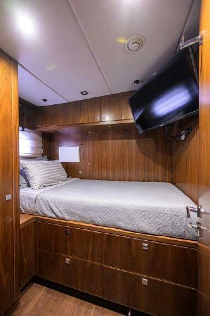 a bed with a television on the wall aboard SECOND AMENDMENT Yacht for Sale