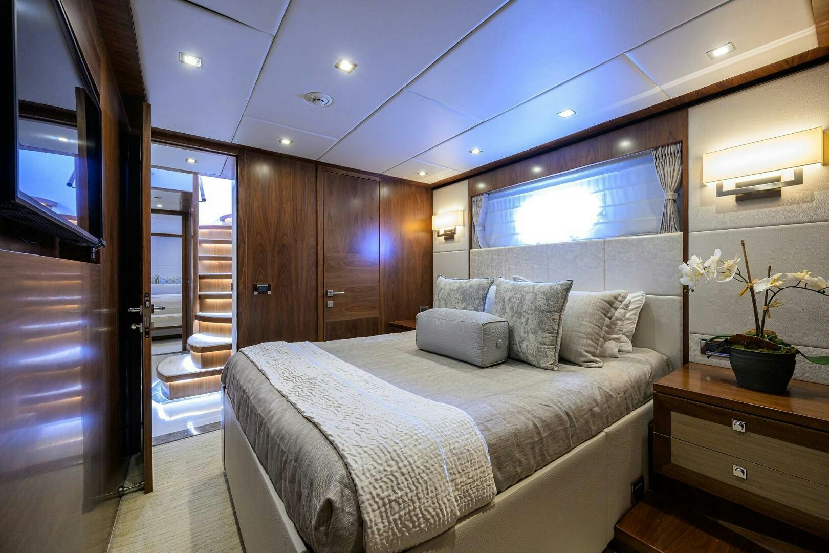 a bedroom with a bed and a wood cabinet aboard SECOND AMENDMENT Yacht for Sale