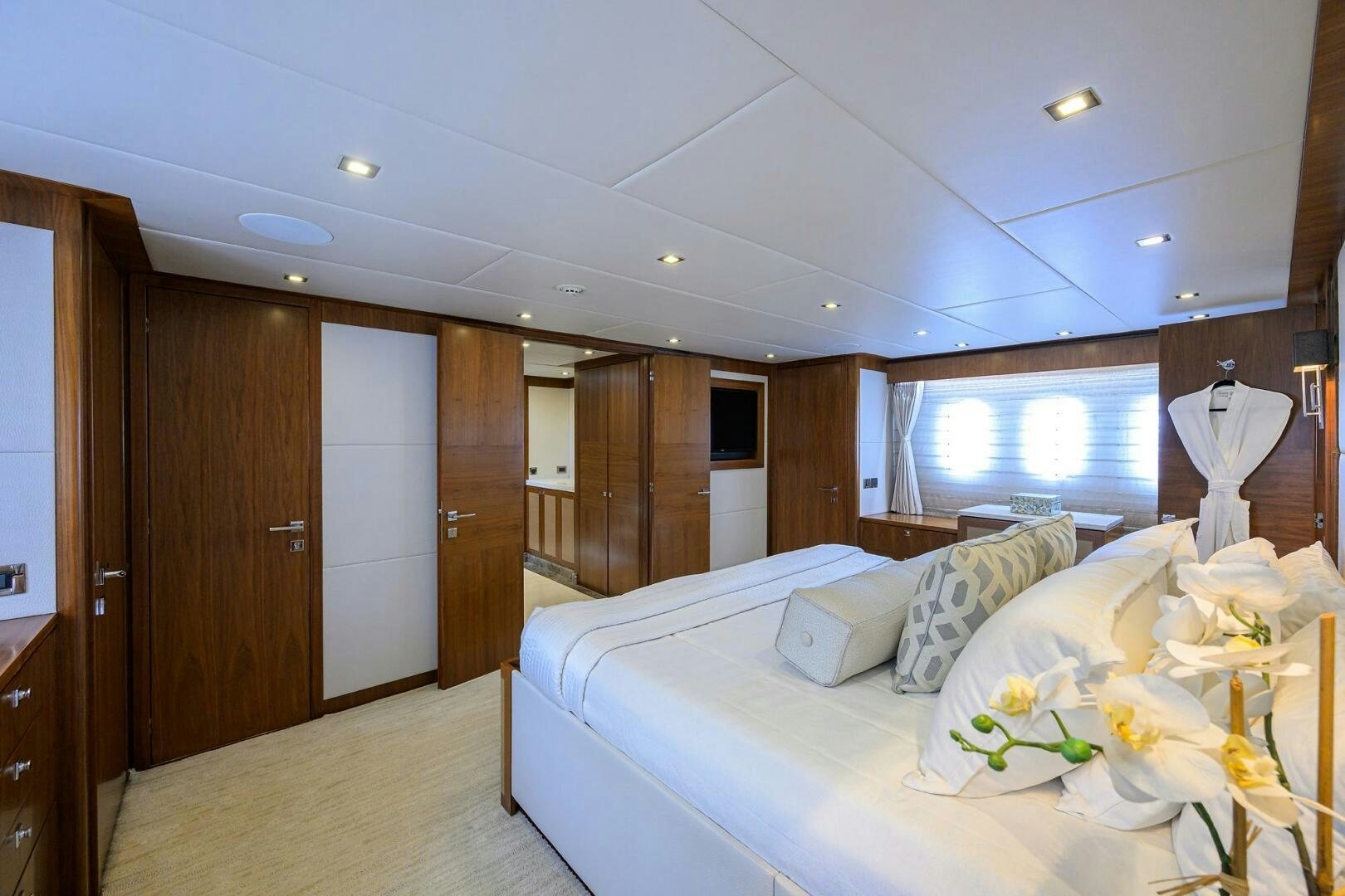 a bedroom with a bed and a wood cabinet aboard SECOND AMENDMENT Yacht for Sale