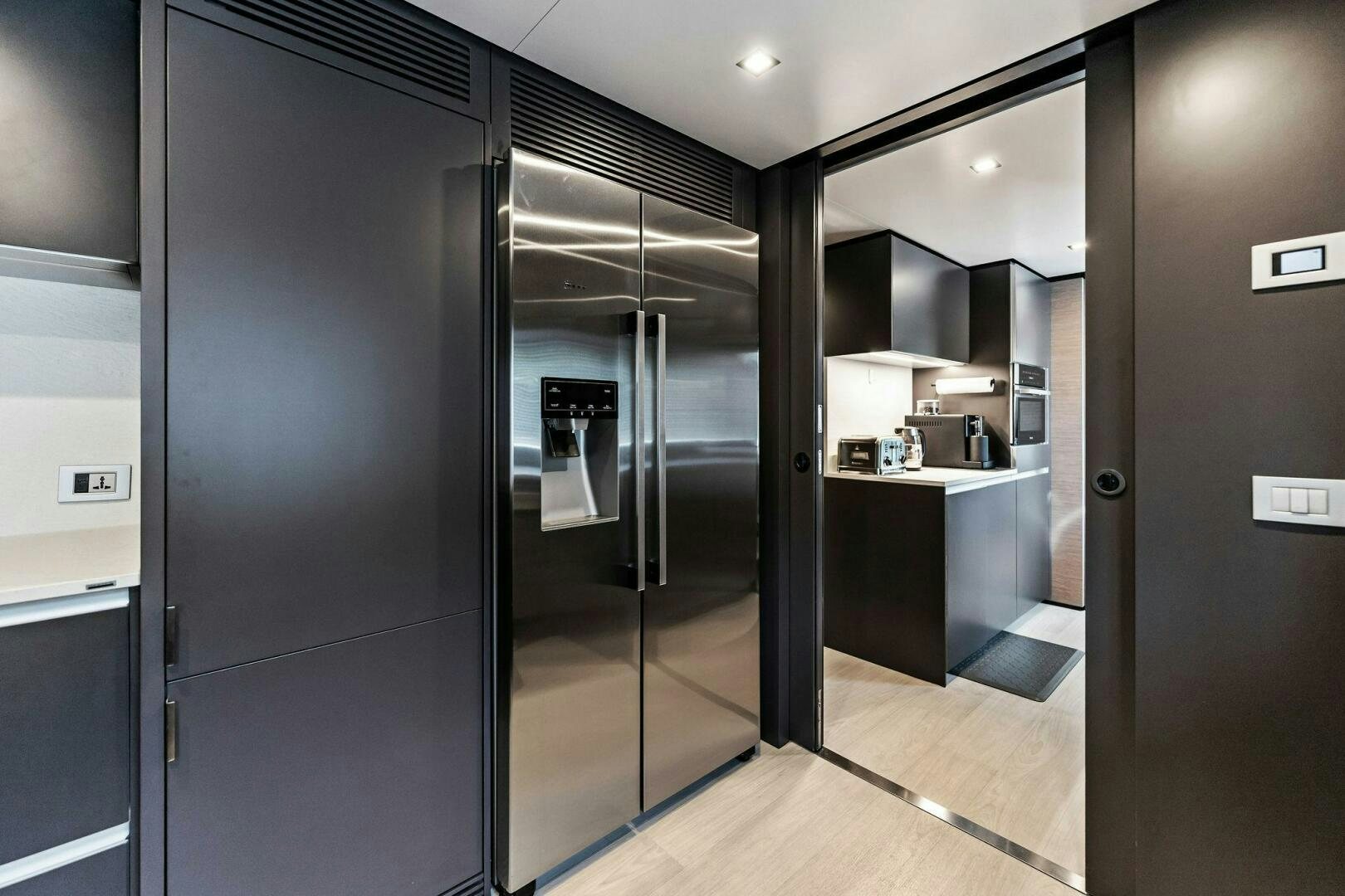 a large room with a large glass door and a large silver refrigerator aboard FAMILIA Yacht for Sale