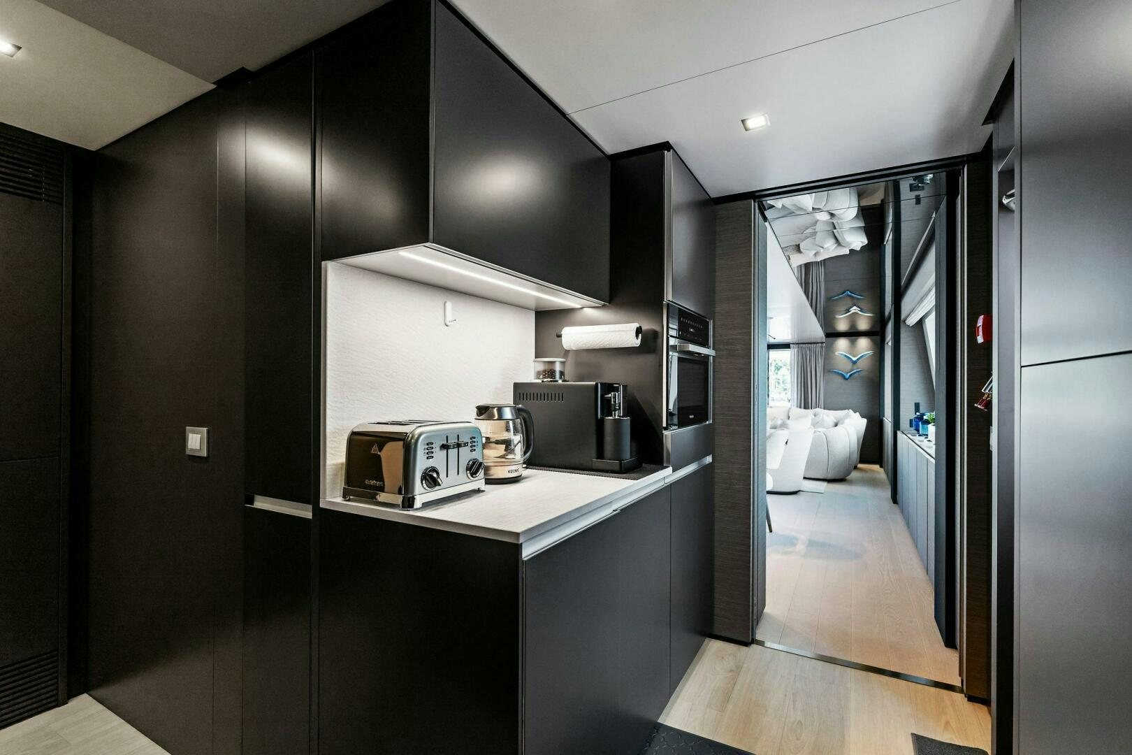 a kitchen with black cabinets aboard FAMILIA Yacht for Sale