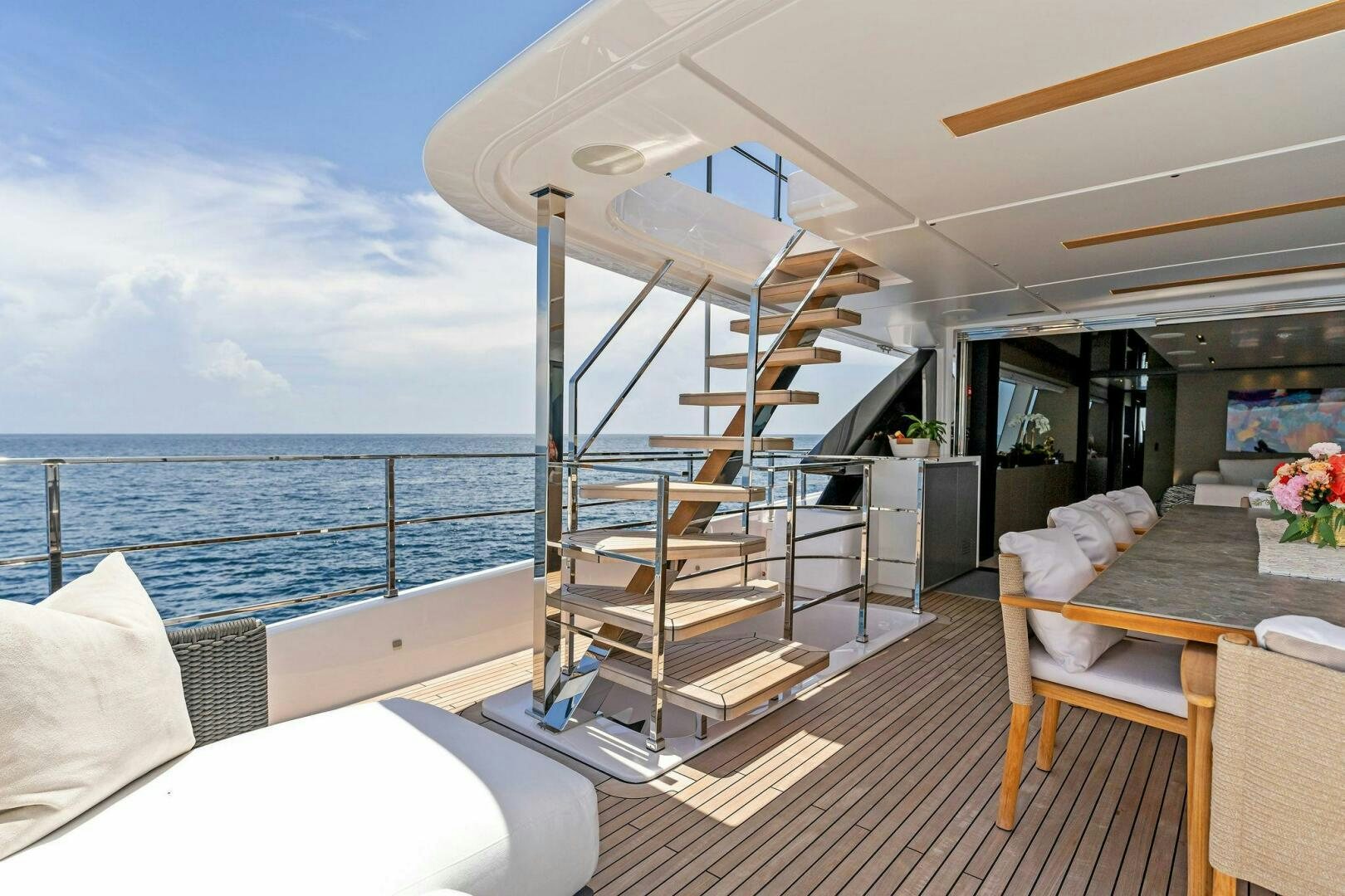 a deck with a large body of water and a staircase aboard FAMILIA Yacht for Sale