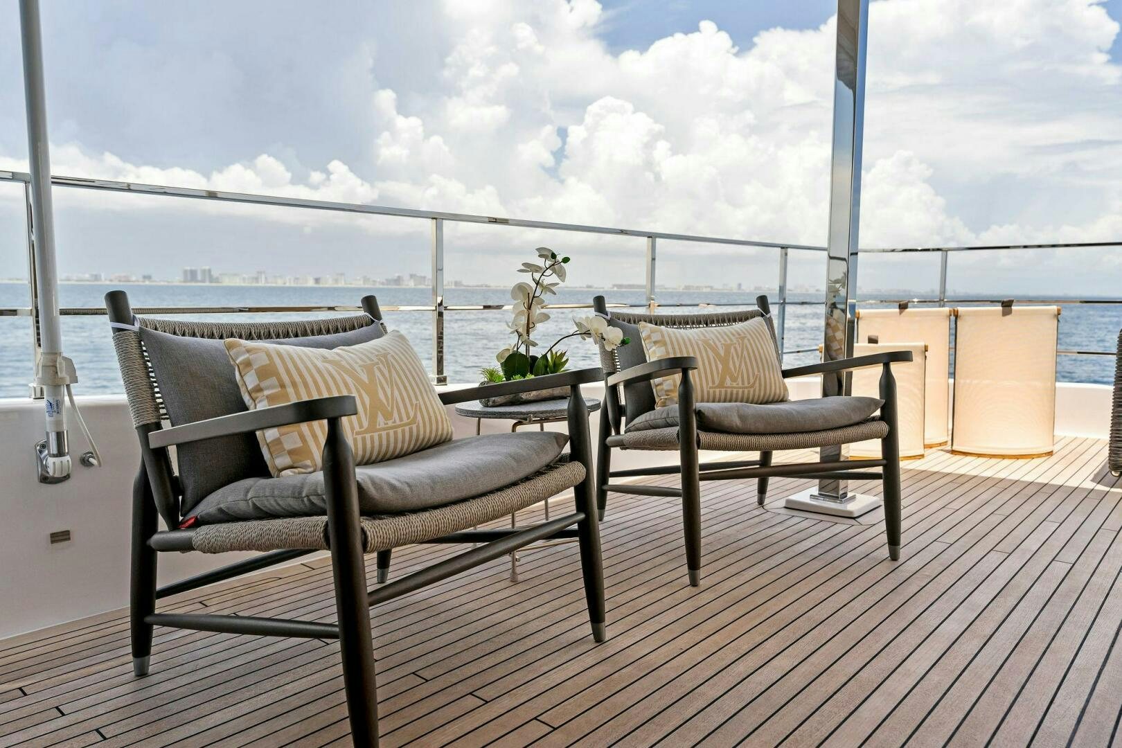 a deck with chairs and a table aboard FAMILIA Yacht for Sale
