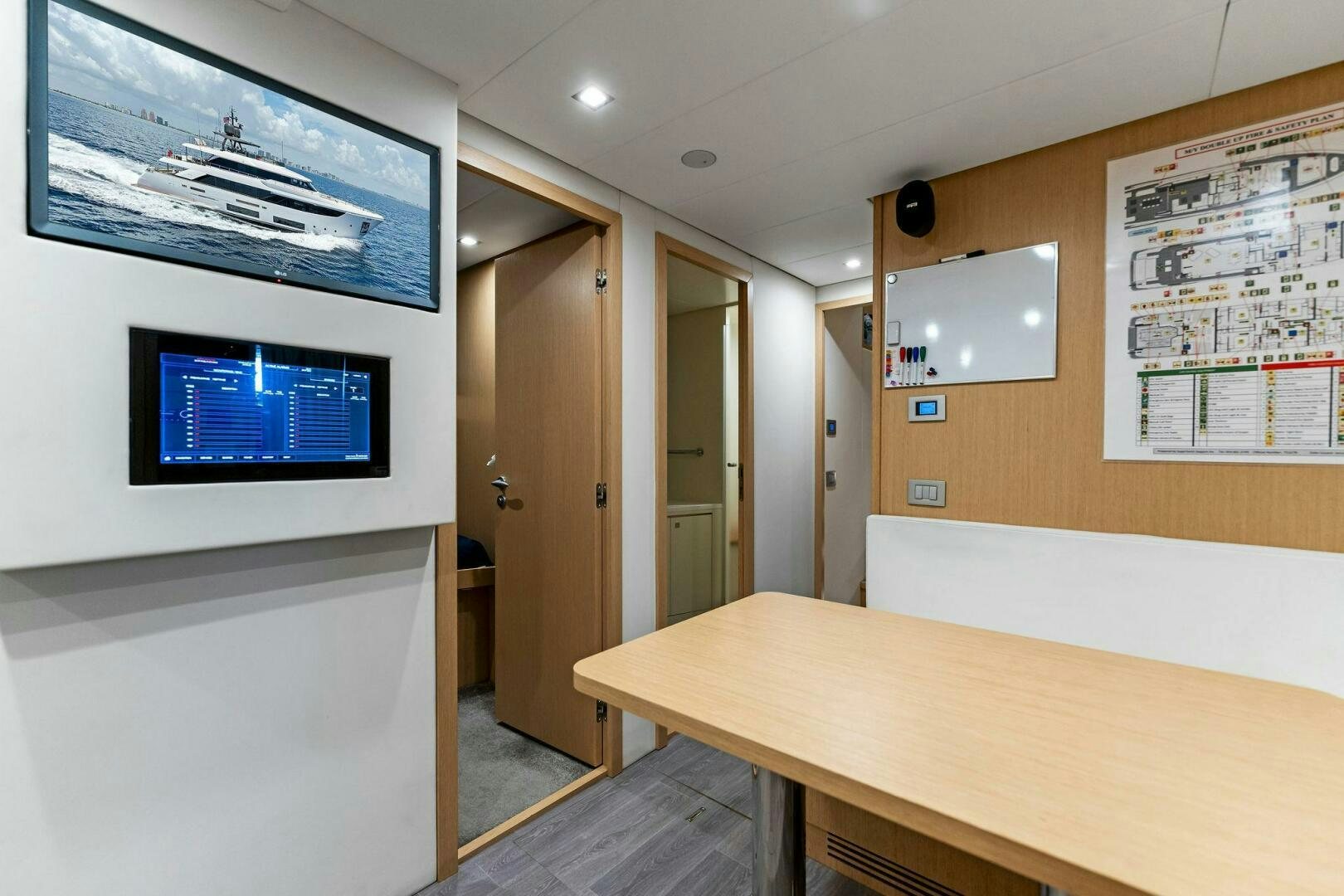 a room with a table and a tv on the wall aboard FAMILIA Yacht for Sale
