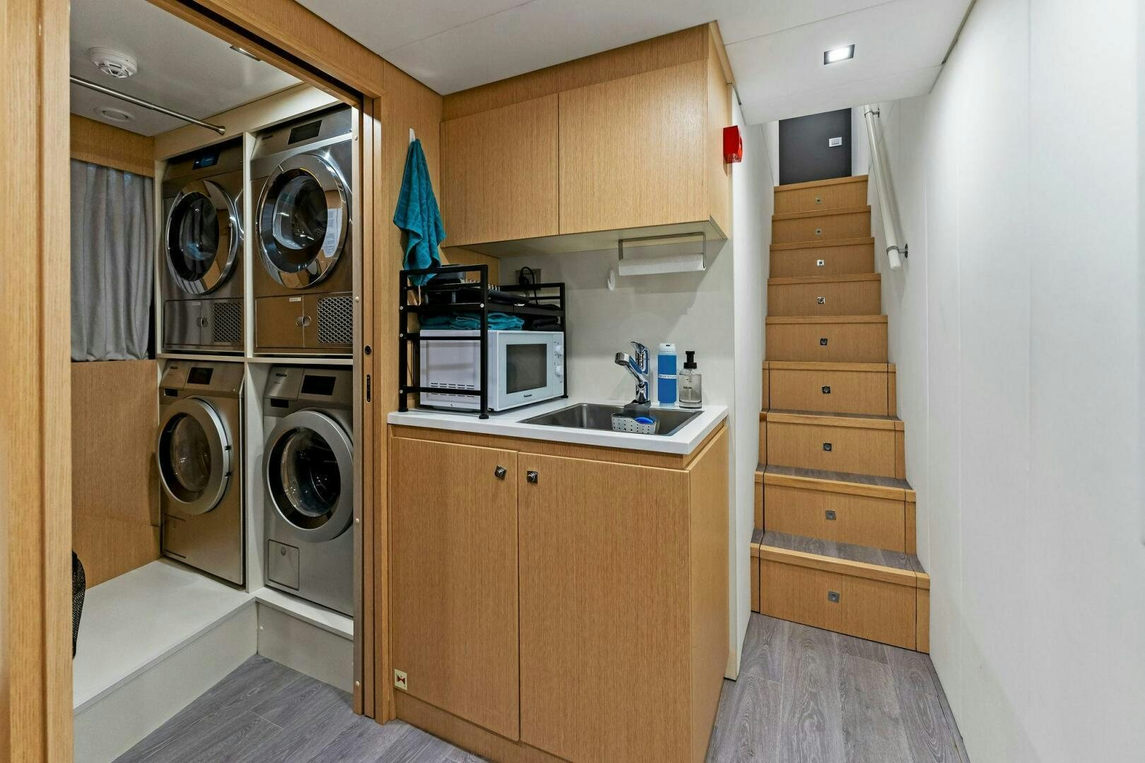 a room with a washer and dryer and a microwave aboard FAMILIA Yacht for Sale