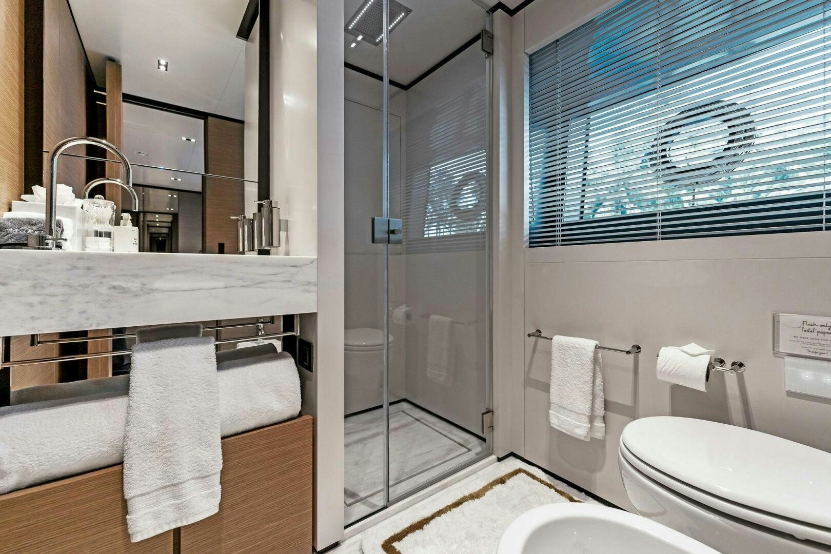 a bathroom with a glass shower aboard FAMILIA Yacht for Sale