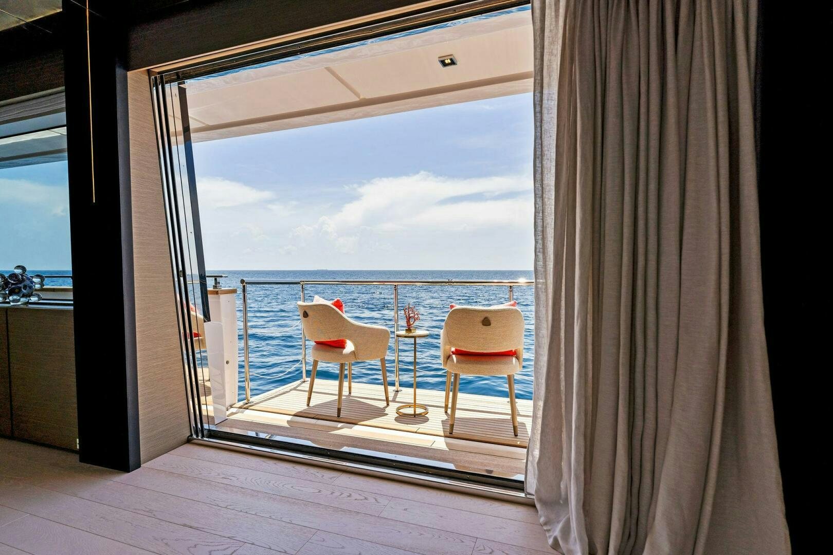 a room with a view of the ocean and a balcony aboard FAMILIA Yacht for Sale