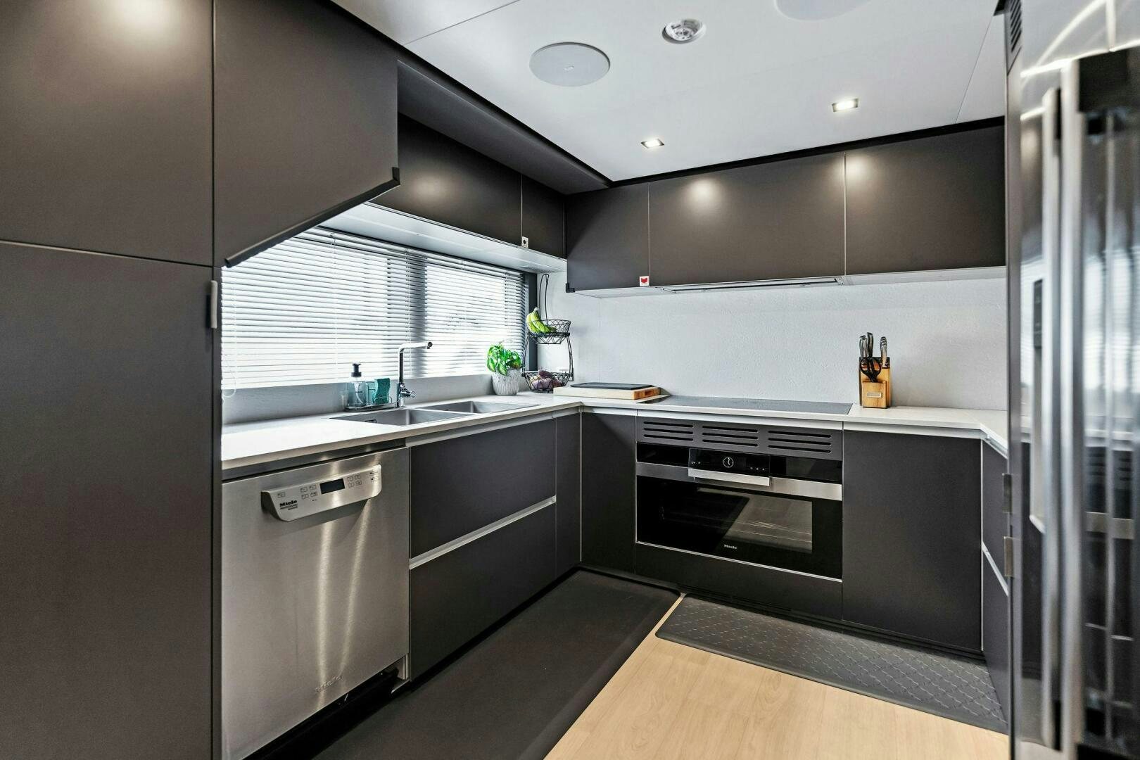 a kitchen with black appliances aboard FAMILIA Yacht for Sale