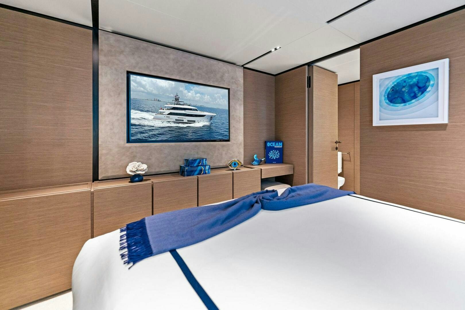a bedroom with a bed and a television on the wall aboard FAMILIA Yacht for Sale