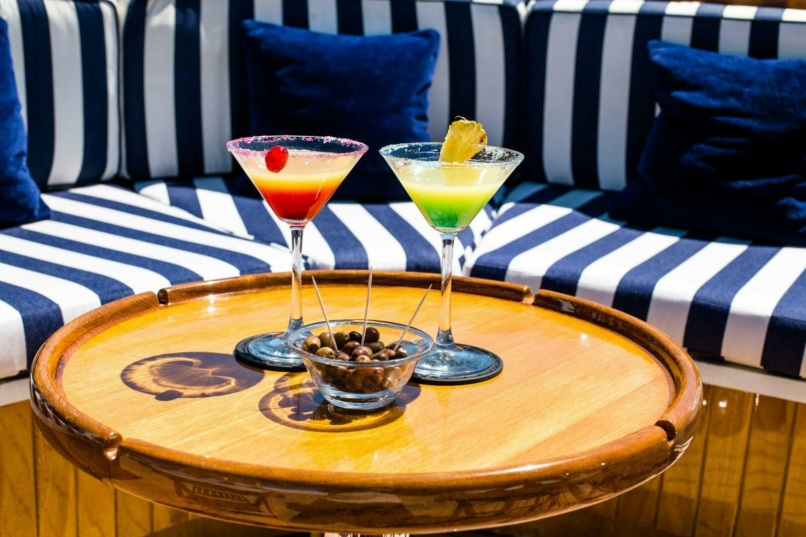 a couple of glasses with different colored liquids on a table aboard STAR OF THE SEA Yacht for Sale