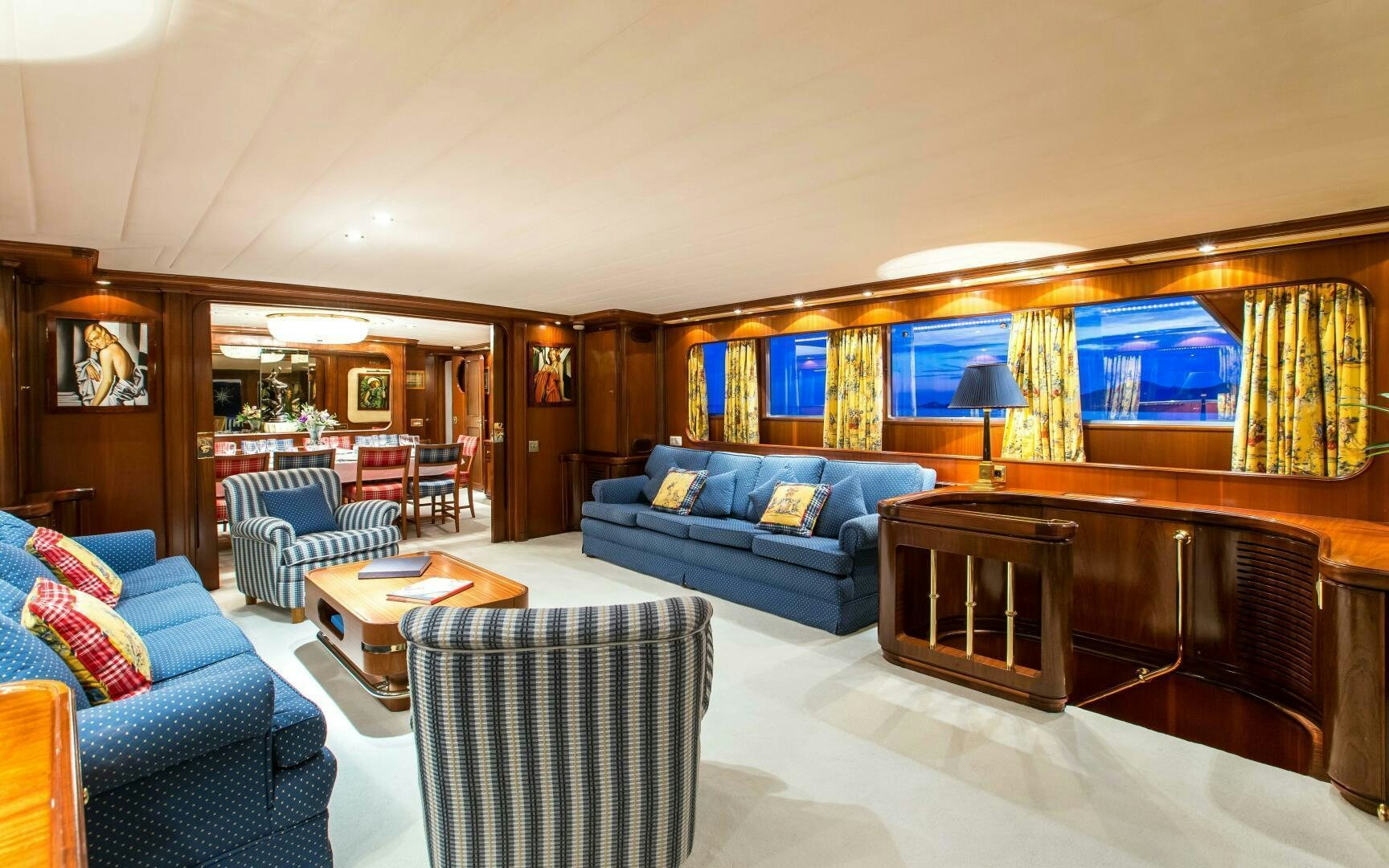 a living room with a blue couch and a wood coffee table aboard STAR OF THE SEA Yacht for Sale