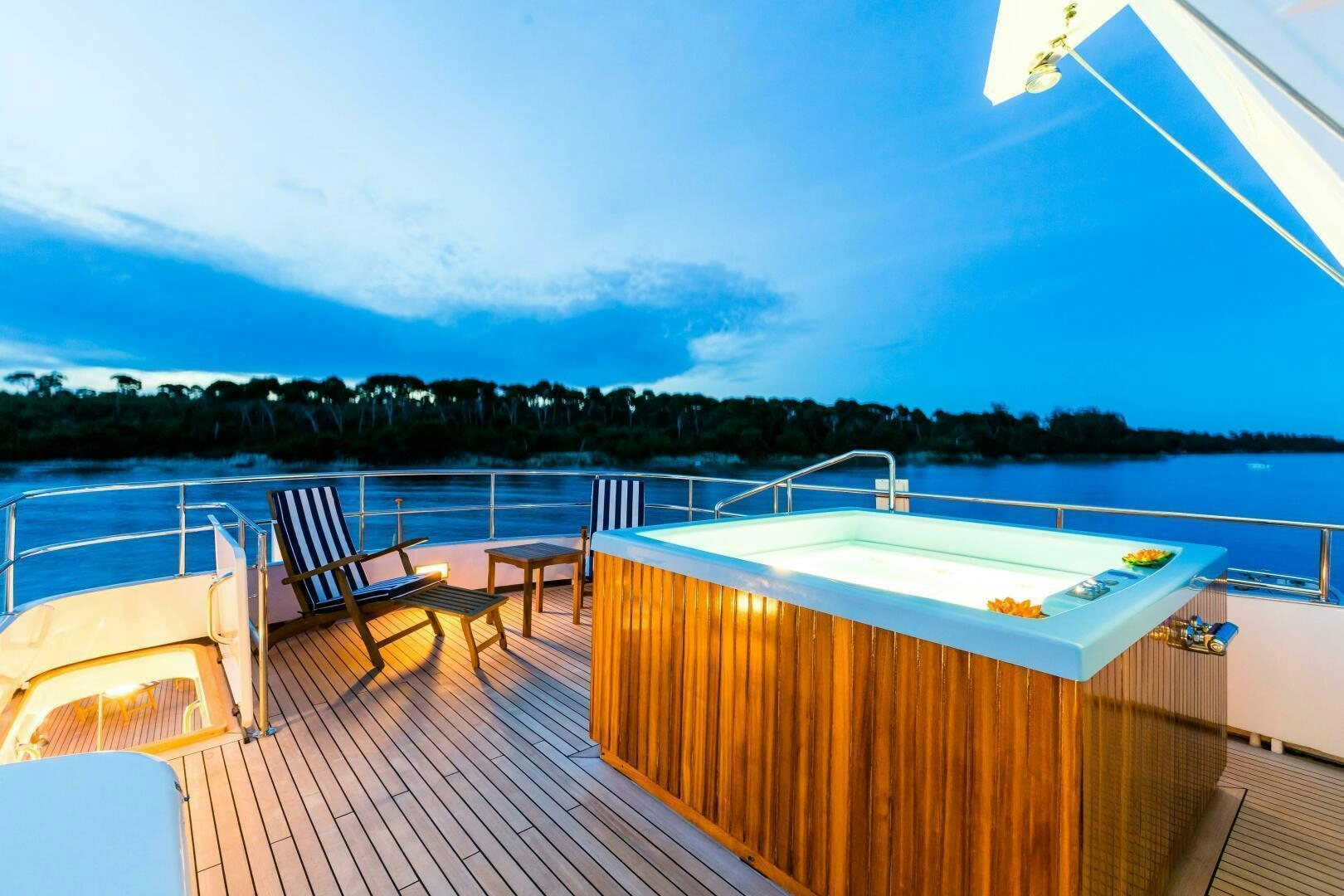 a deck with a pool and trees in the background aboard STAR OF THE SEA Yacht for Sale