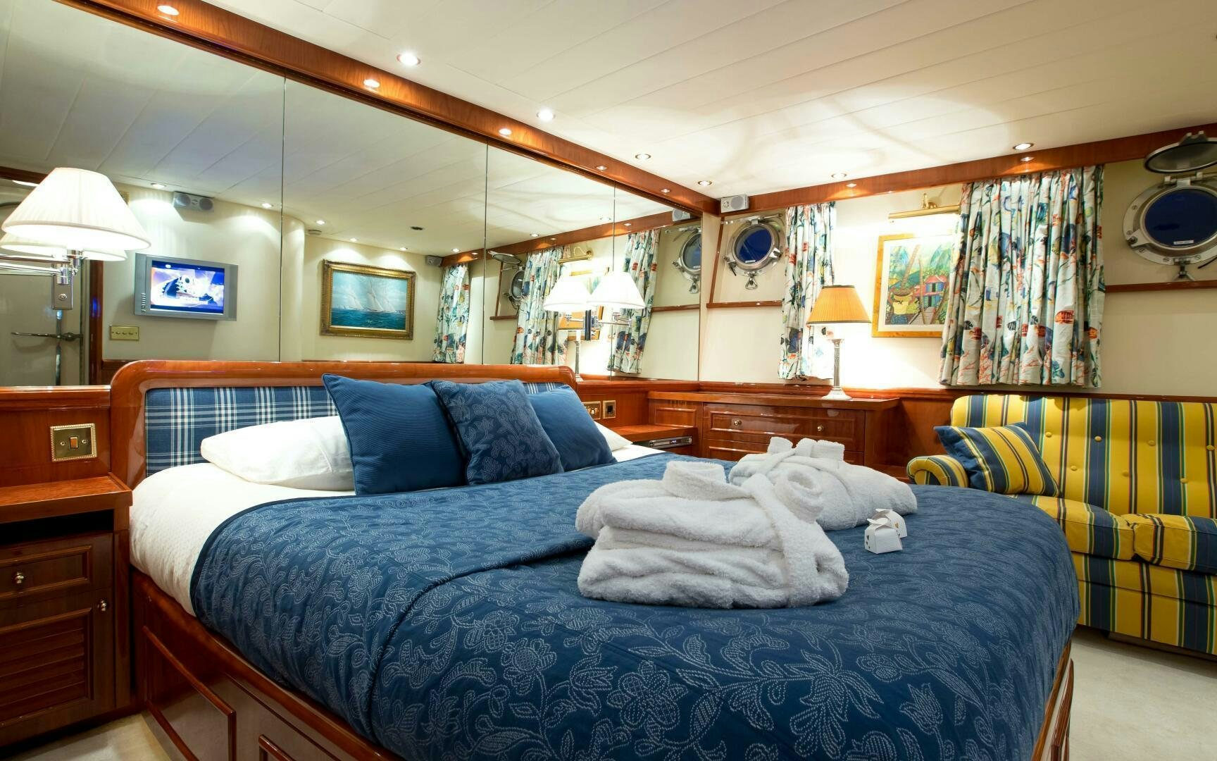 a bedroom with a bed and a blue bed spread aboard STAR OF THE SEA Yacht for Sale