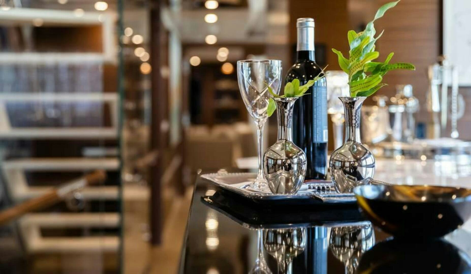 a table with wine glasses and bottles aboard NORTHLAND Yacht for Sale