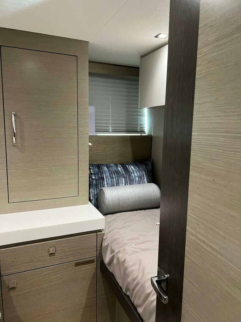 a bedroom with a bed and a window aboard HAPPY HEART Yacht for Sale