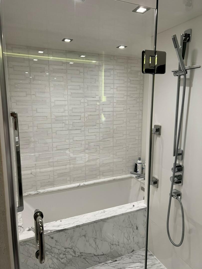 a bathroom with a bathtub and shower aboard HAPPY HEART Yacht for Sale