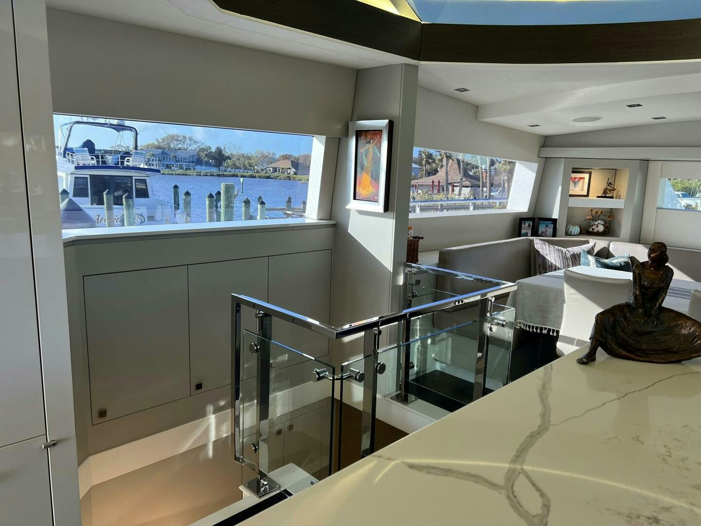 a room with a glass railing and a view of the water aboard HAPPY HEART Yacht for Sale