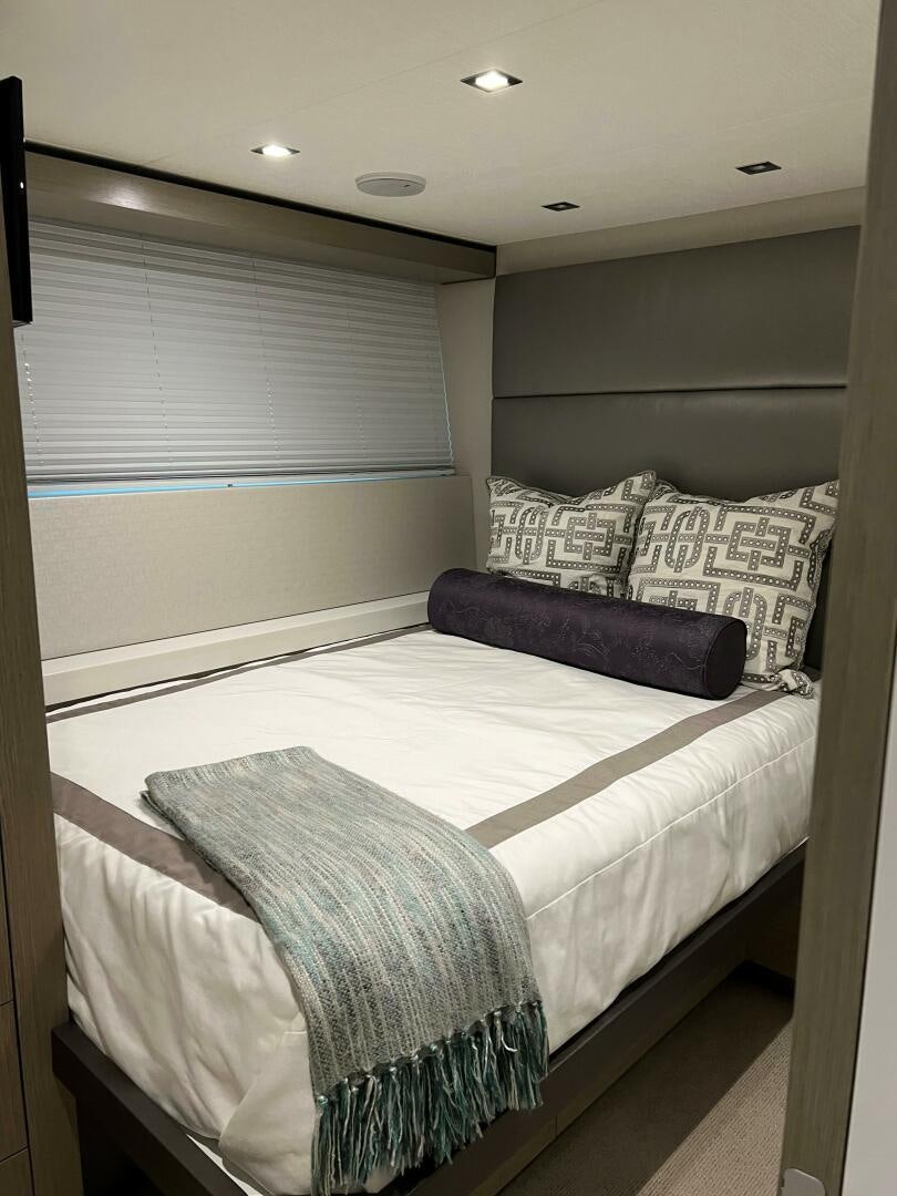 a bed with a white sheet and pillows aboard HAPPY HEART Yacht for Sale