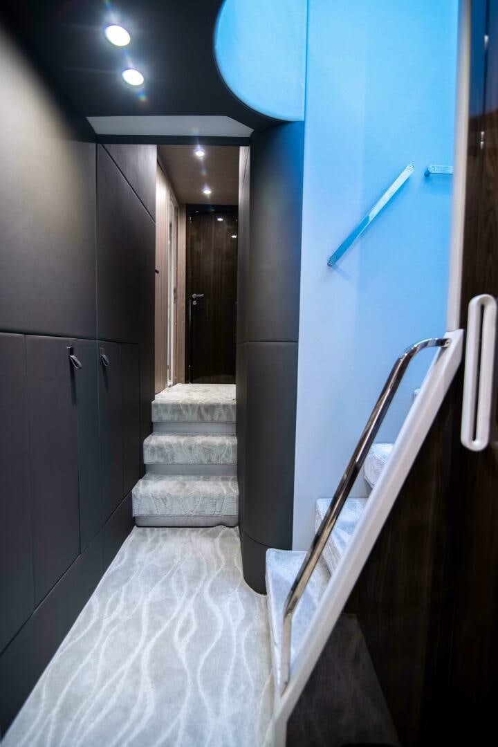a staircase with a blue wall aboard TRIPLE PLAY Yacht for Sale