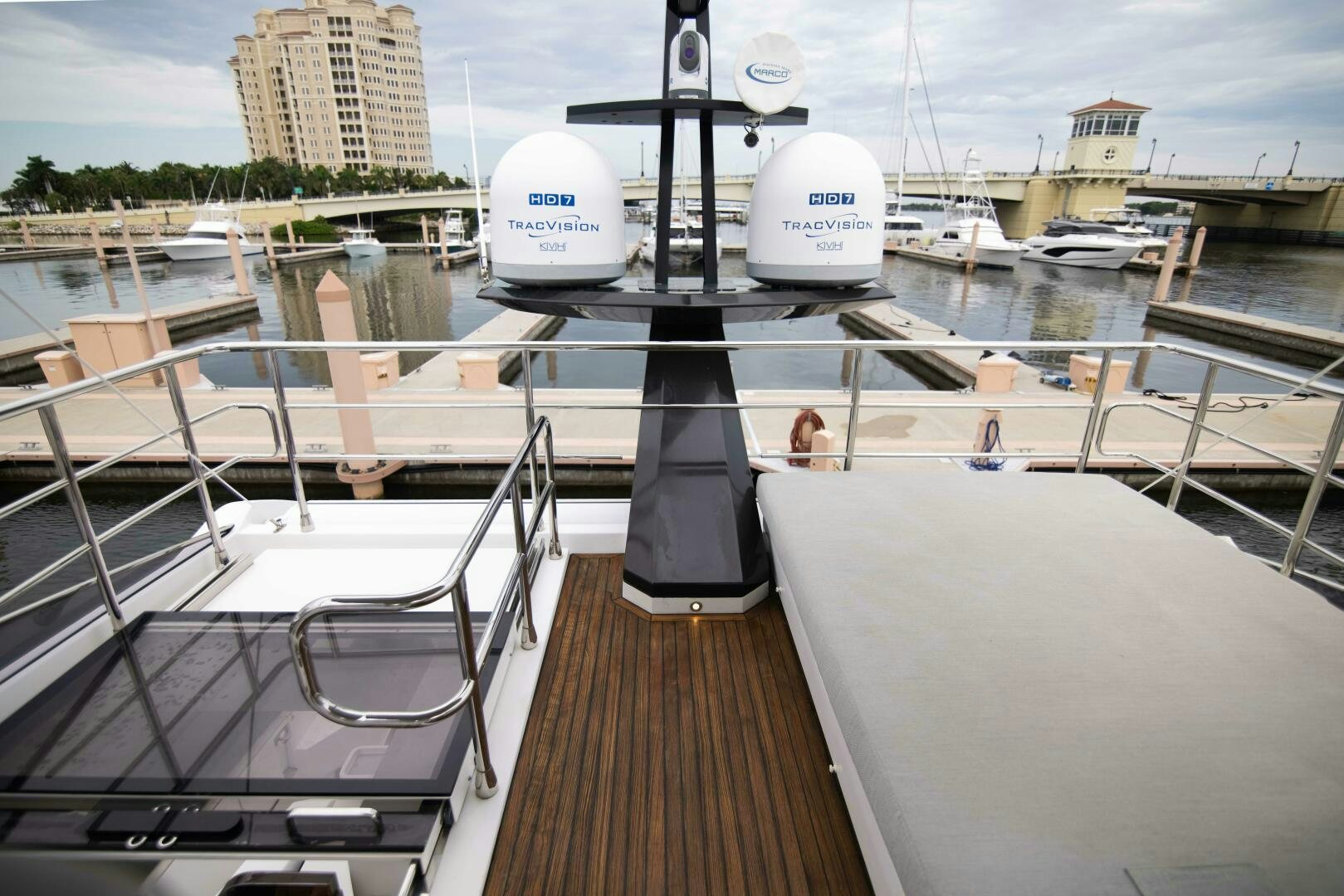 a deck with a large white boat and a large white building in the background aboard TRIPLE PLAY Yacht for Sale