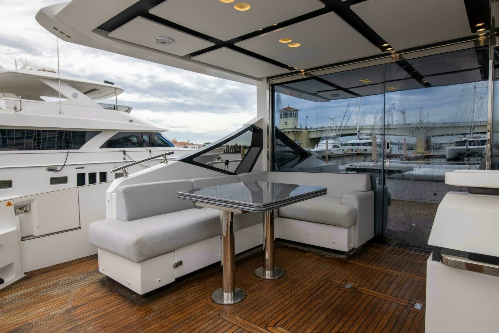 a white lounge chair next to a table and a large white sofa aboard TRIPLE PLAY Yacht for Sale