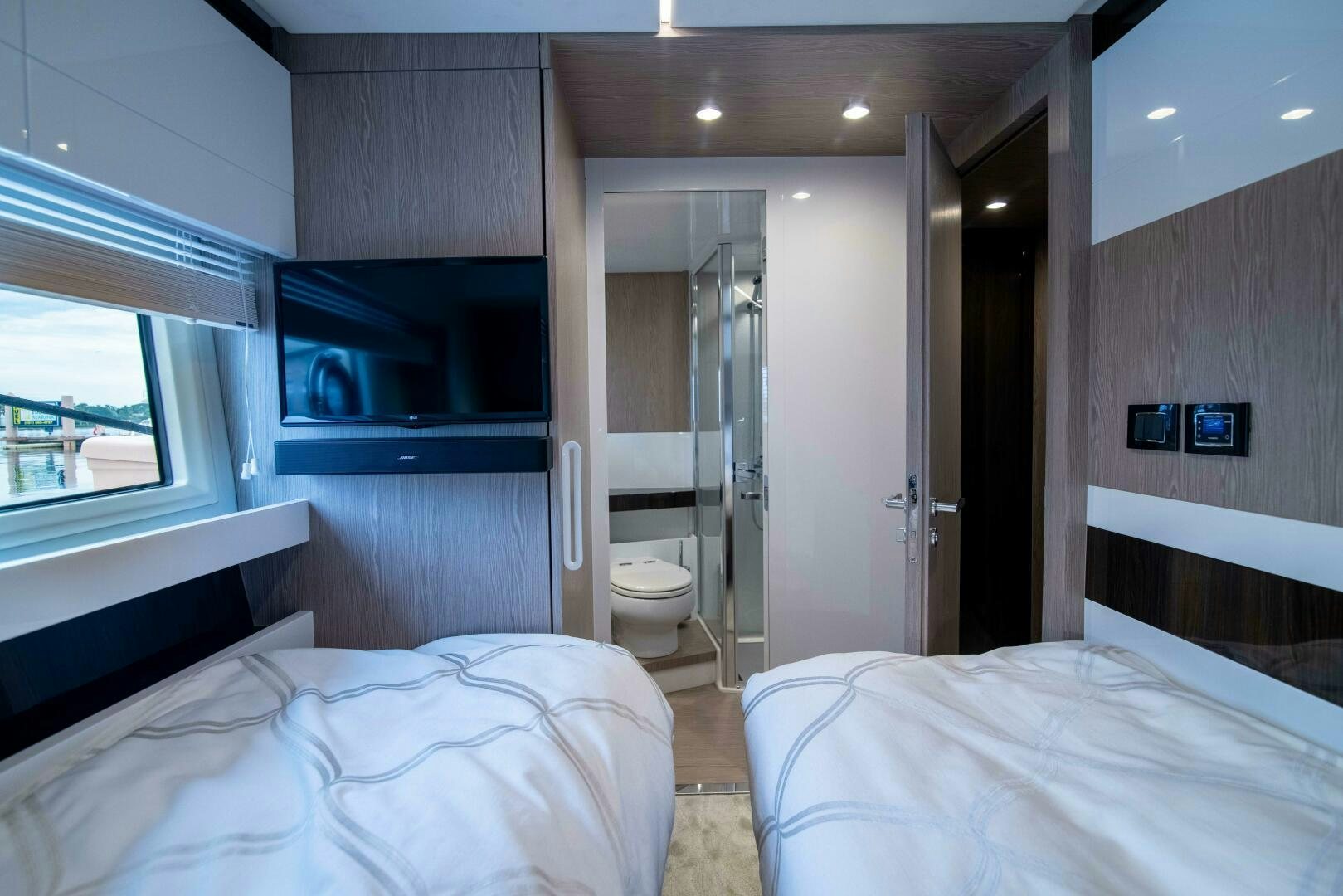 a bedroom with a bed and a television aboard TRIPLE PLAY Yacht for Sale