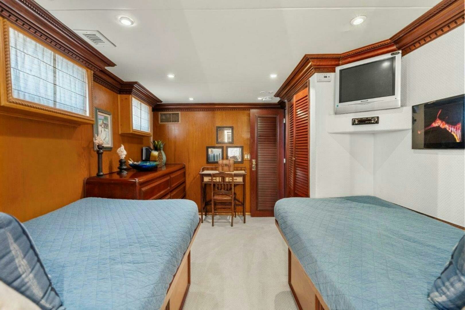 a bedroom with a tv and a bed aboard ENVISION Yacht for Sale