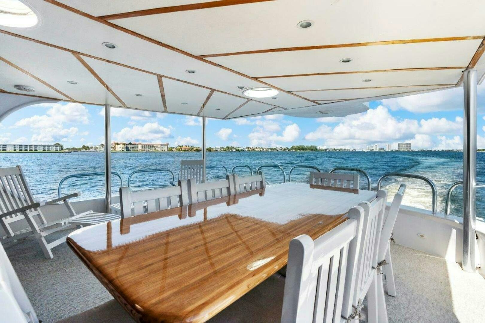 a deck with chairs and tables on it aboard ENVISION Yacht for Sale