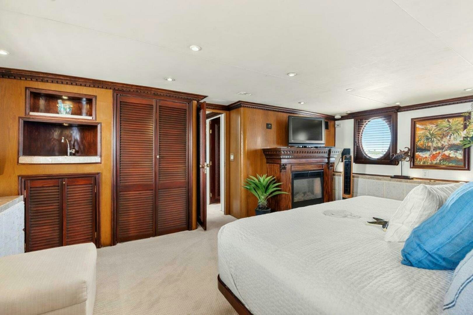 a bedroom with a bed and a television aboard ENVISION Yacht for Sale