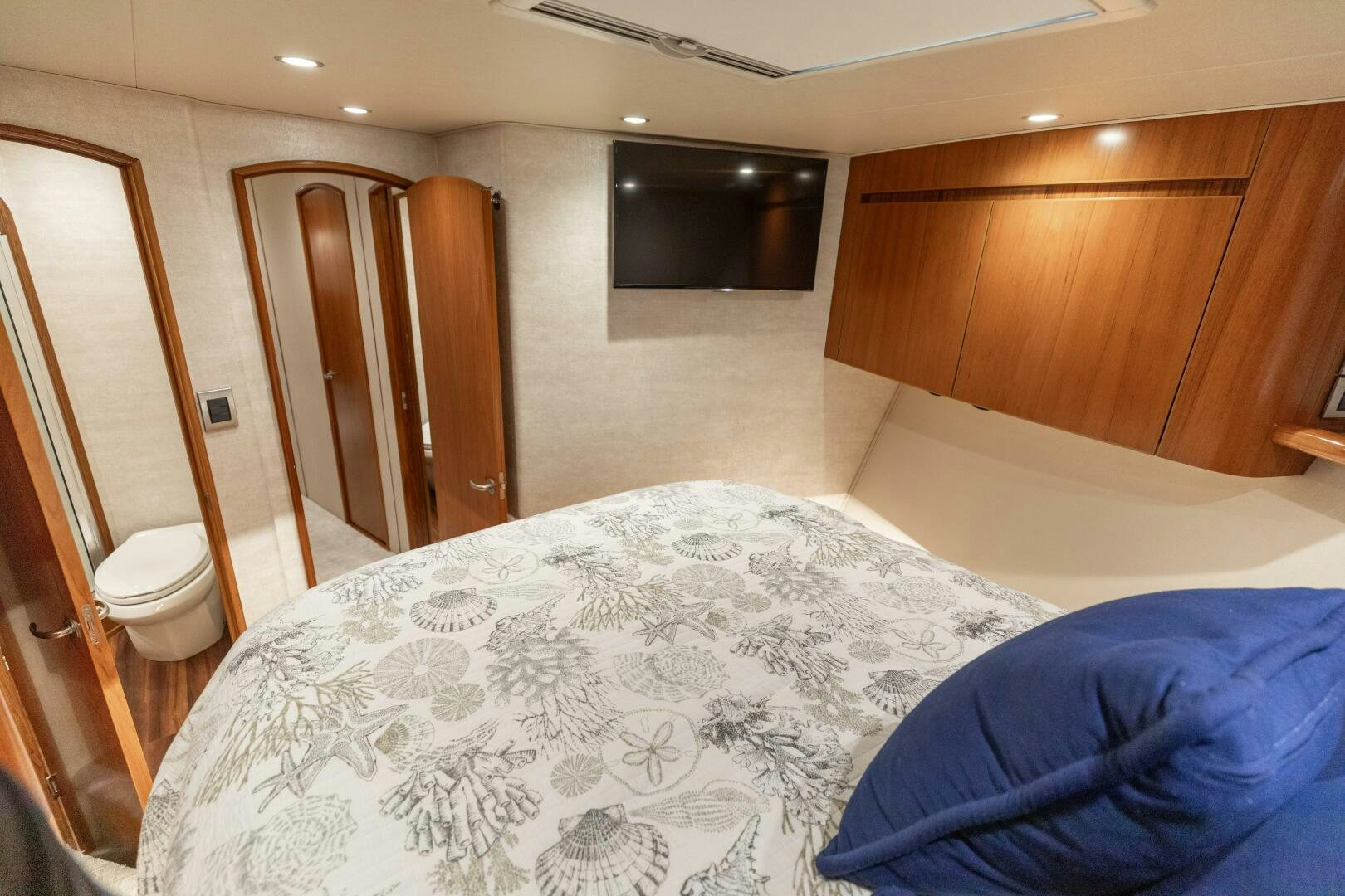 a bedroom with a bed and a wood cabinet aboard SMOOTH RIDE Yacht for Sale