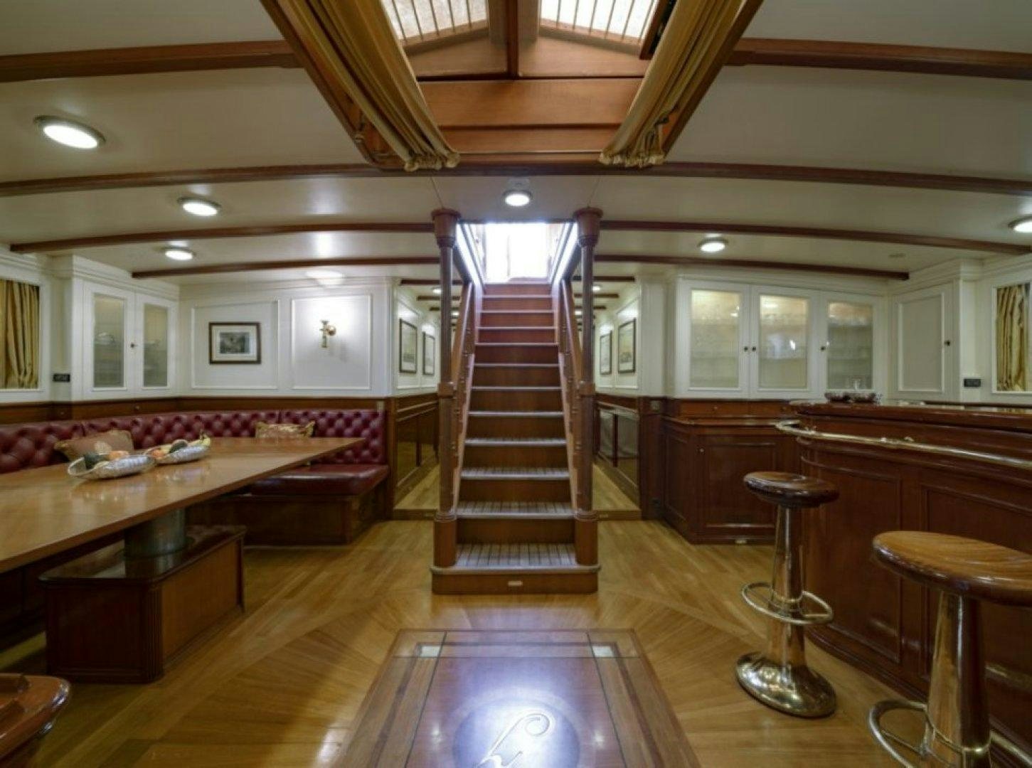 a large room with a staircase and a glass case aboard INVADER Yacht for Charter