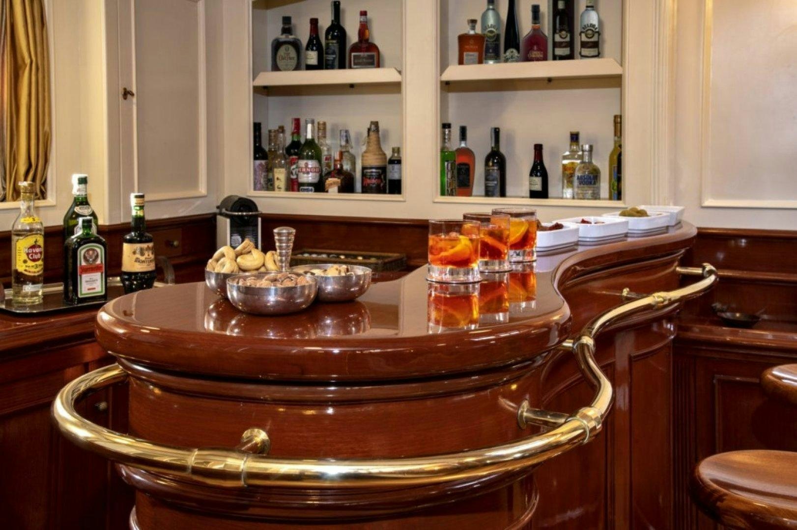 a wooden table with bottles and a basket of food on it aboard INVADER Yacht for Charter